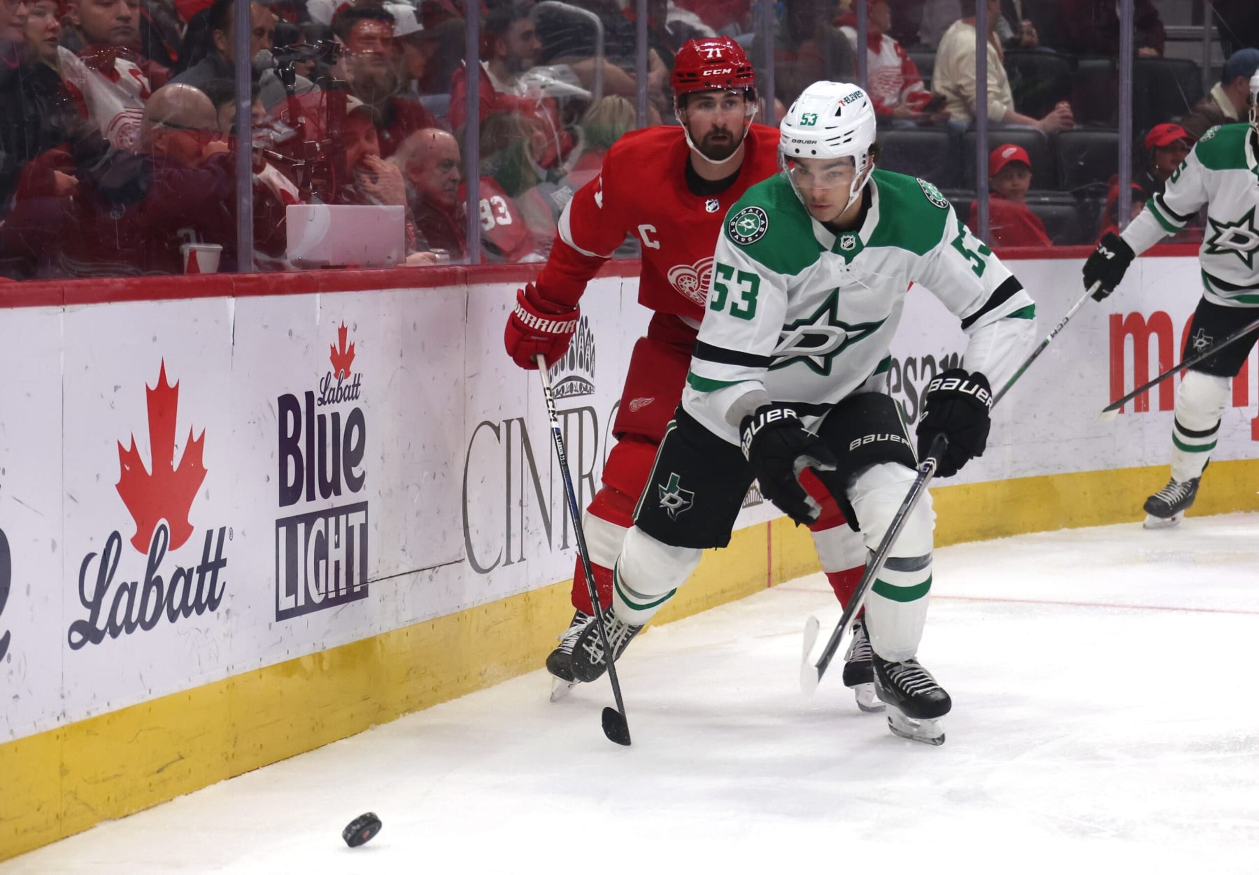 DETROIT, MICHIGAN - JANUARY 23: Wyatt Johnston #53 of the Dallas Stars controls the puck in front of Dylan Larkin #71 of the Detroit Red Wings during the first period at Little Caesars Arena on January 23, 2024 in Detroit, Michigan. (Photo by Gregory Shamus/Getty Images)