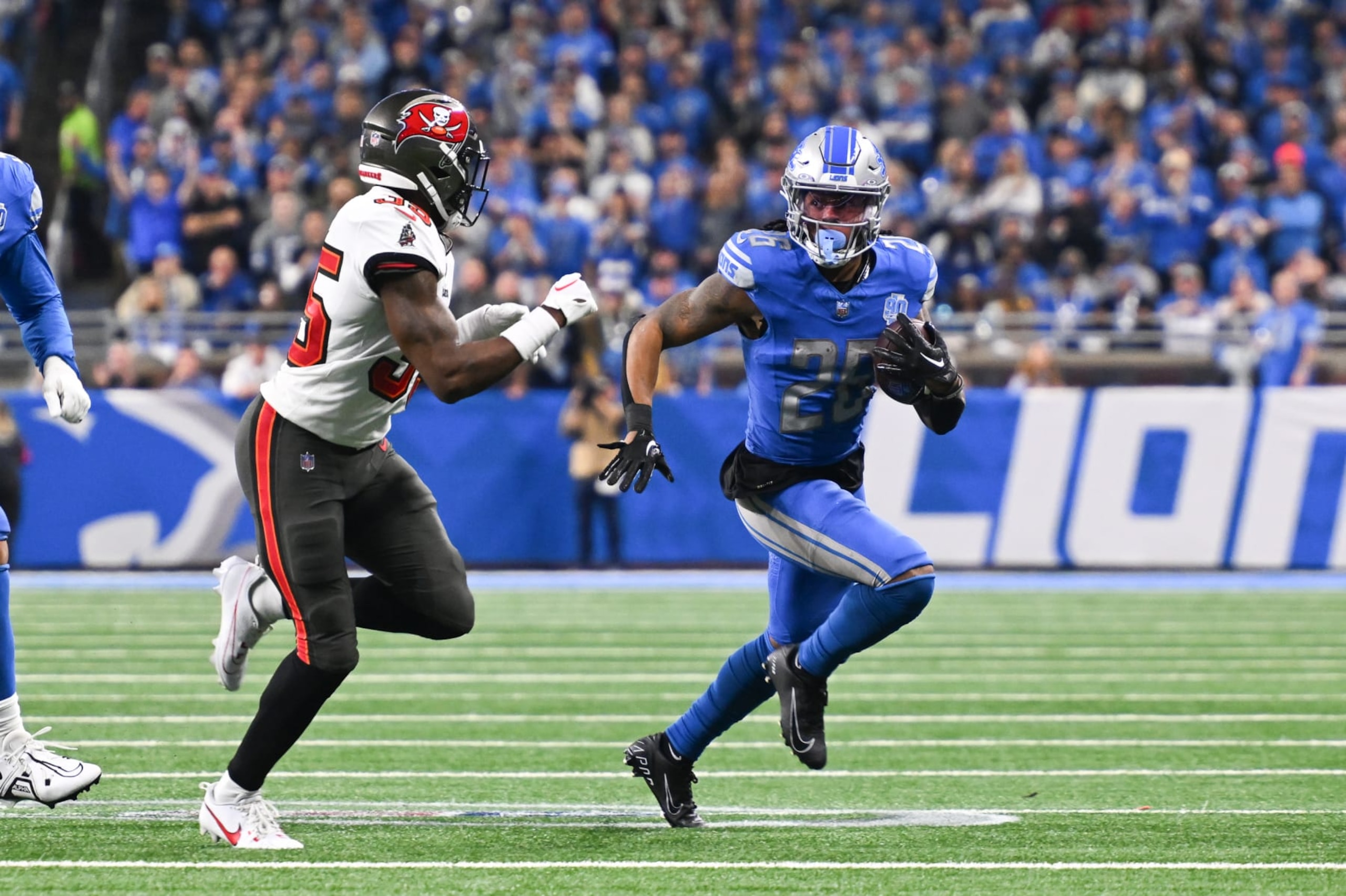 DETROIT, MI - JANUARY 21: Detroit Lions running back Jahmyr Gibbs (26) runs wide with Tampa Bay Buccaneers cornerback Jamel Dean (35) chasing him down during the NFC Divisional playoff game between the Detroit Lions and the Tampa Bay Buccaneers on Sunday January 21, 2023 at Ford Field in Detroit, MI. (Photo by Steven King/Icon Sportswire via Getty Images) DETROIT, MI - JANUARY 21: Detroit Lions running back Jahmyr Gibbs (26) runs wide with Tampa Bay Buccaneers cornerback Jamel Dean (35) chasing him down during the NFC Divisional playoff game between the Detroit Lions and the Tampa Bay Buccaneers on Sunday January 21, 2023 at Ford Field in Detroit, MI. (Photo by Steven King/Icon Sportswire via Getty Images)