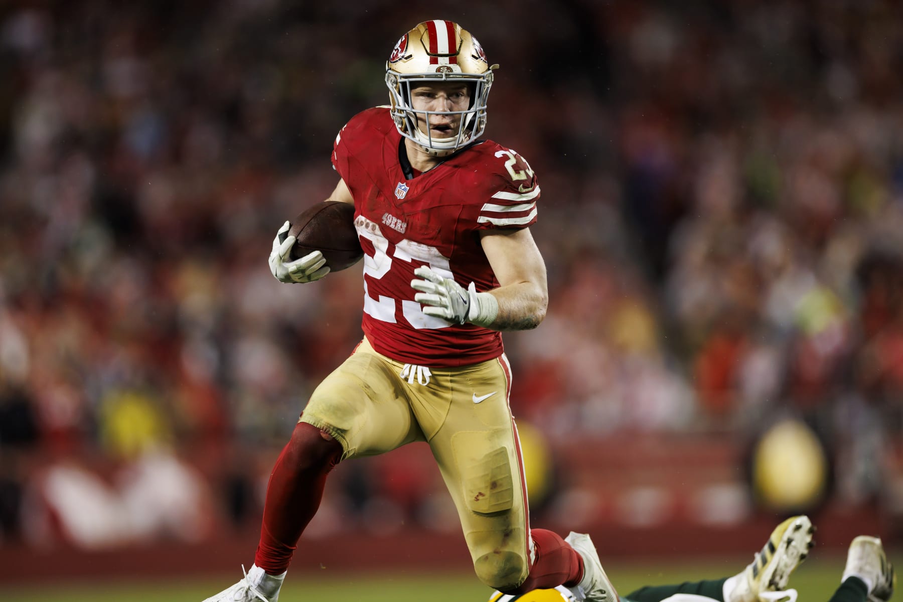 SANTA CLARA, CALIFORNIA - JANUARY 20: Christian McCaffrey #23 of the San Francisco 49ers carries the ball on a run play during an NFC divisional round playoff football game against the Green Bay Packers at Levi's Stadium on January 20, 2024 in Santa Clara, California. (Photo by Ryan Kang/Getty Images)