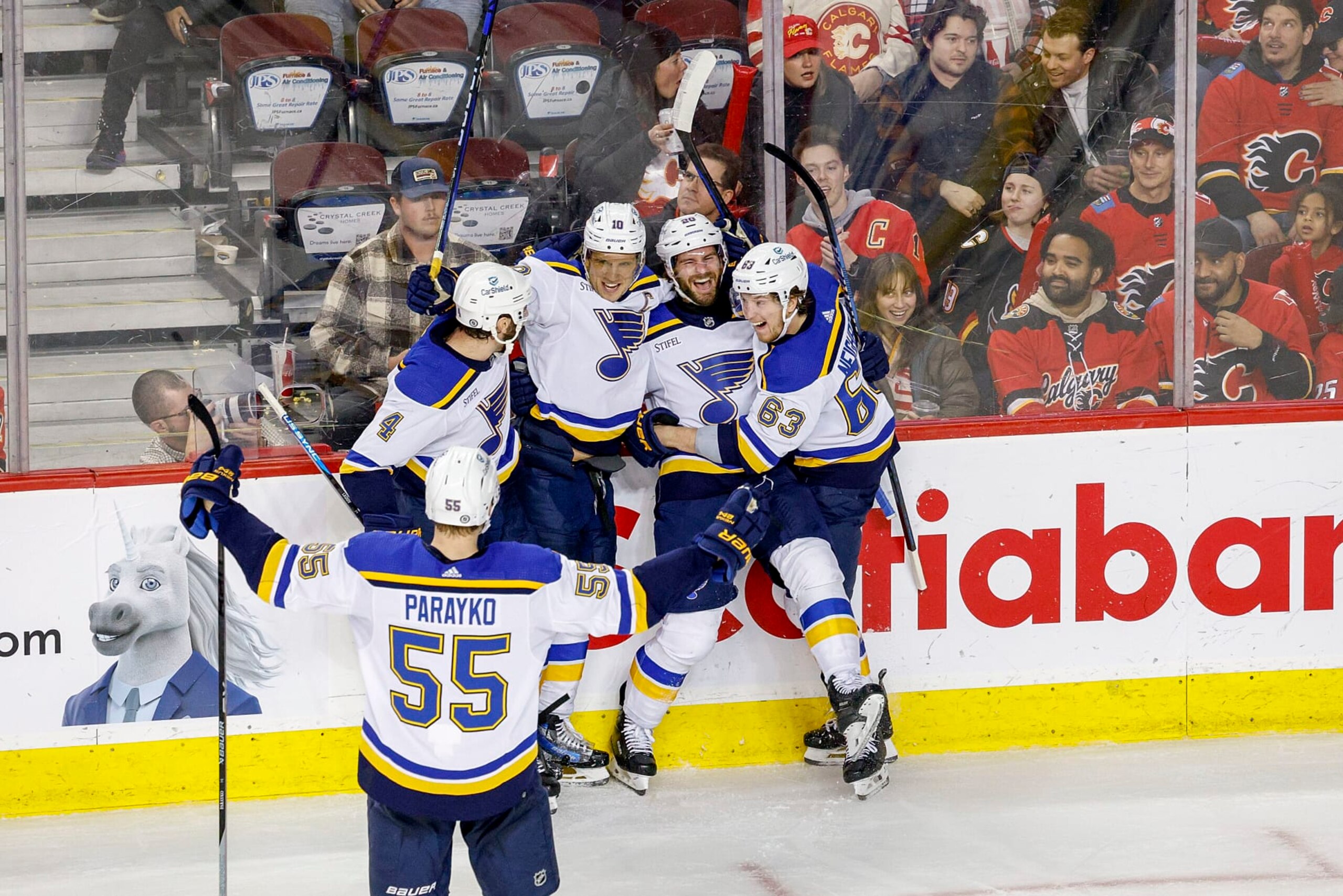CALGARY, AB - JANUARY 23: Brayden Schenn #10, Brandon Saad #20, Jake Neighbours #63 of the St Louis Blues celebrate on ice after a goal against the Calgary Flames at Scotiabank Saddledome on January 23, 2024 in Calgary, Alberta, Canada. (Photo by Jenn Pierce/NHLI via Getty Images)