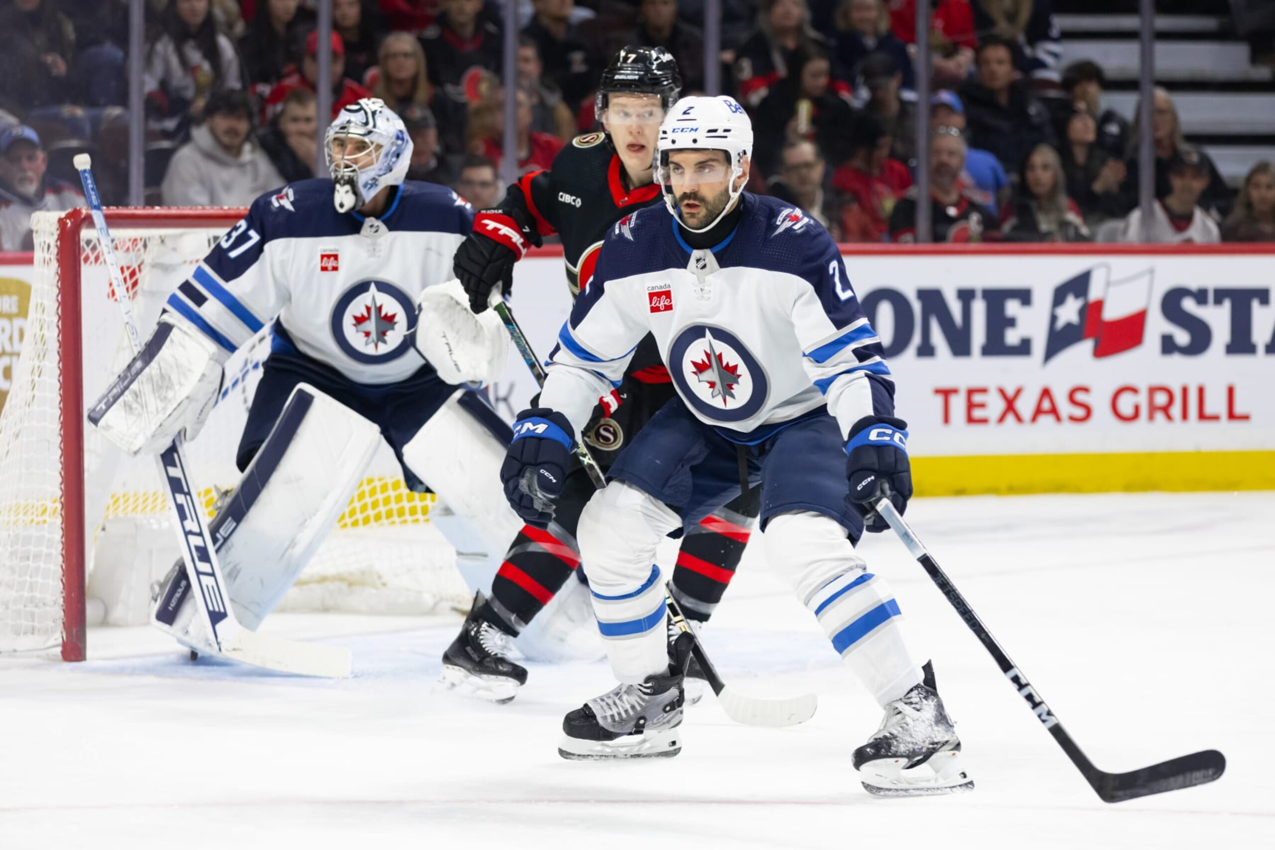 OTTAWA, ON - JANUARY 20: Winnipeg Jets Defenceman Dylan DeMelo (2) keeps eyes on the play in the defensive zone during first period National Hockey League action between the Winnipeg Jets and Ottawa Senators on January 20, 2024, at Canadian Tire Centre in Ottawa, ON, Canada. (Photo by Richard A. Whittaker/Icon Sportswire via Getty Images)