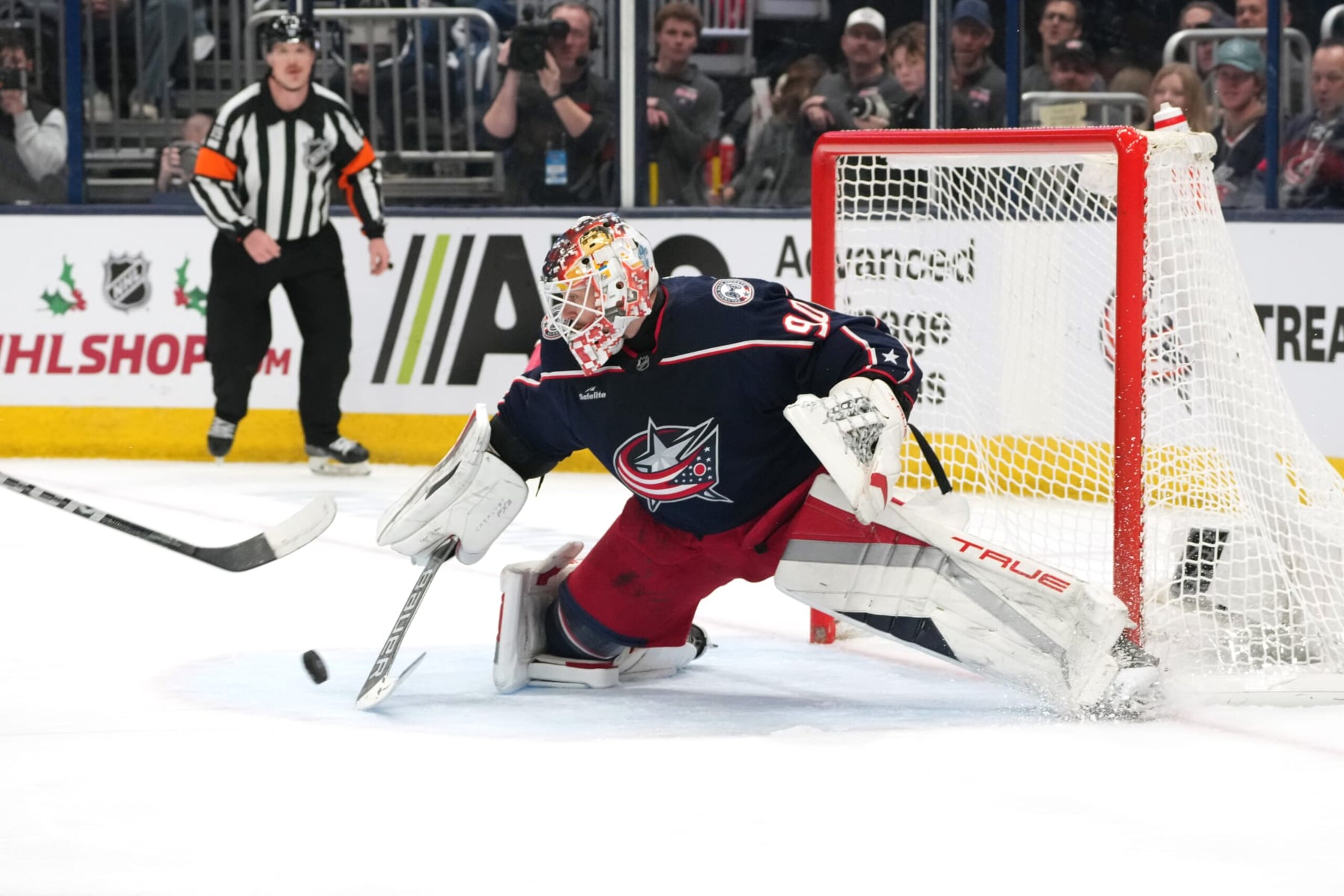 COLUMBUS, OHIO - NOVEMBER 22: Elvis Merzlikins #90 of the Columbus Blue Jackets deflects the puck with his stick during the first period against the Chicago Blackhawks at Nationwide Arena on November 22, 2023 in Columbus, Ohio. (Photo by Jason Mowry/Getty Images)