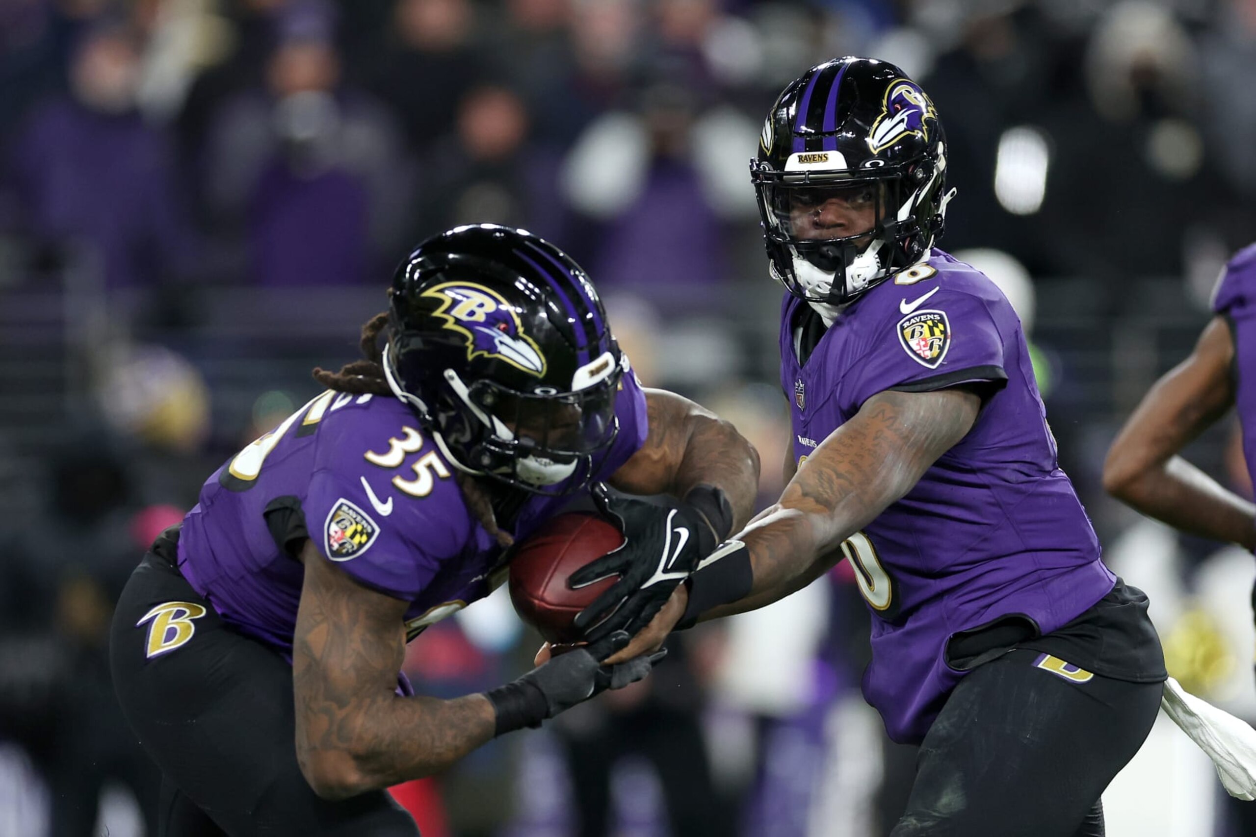 BALTIMORE, MARYLAND - JANUARY 20: Quarterback Lamar Jackson #8 hands the ball off to running back Gus Edwards #35 of the Baltimore Ravens against the Houston Texans during the AFC Divisional Playoff game at M&T Bank Stadium on January 20, 2024 in Baltimore, Maryland. (Photo by Rob Carr/Getty Images) BALTIMORE, MARYLAND - JANUARY 20: Quarterback Lamar Jackson #8 hands the ball off to running back Gus Edwards #35 of the Baltimore Ravens against the Houston Texans during the AFC Divisional Playoff game at M&T Bank Stadium on January 20, 2024 in Baltimore, Maryland. (Photo by Rob Carr/Getty Images)
