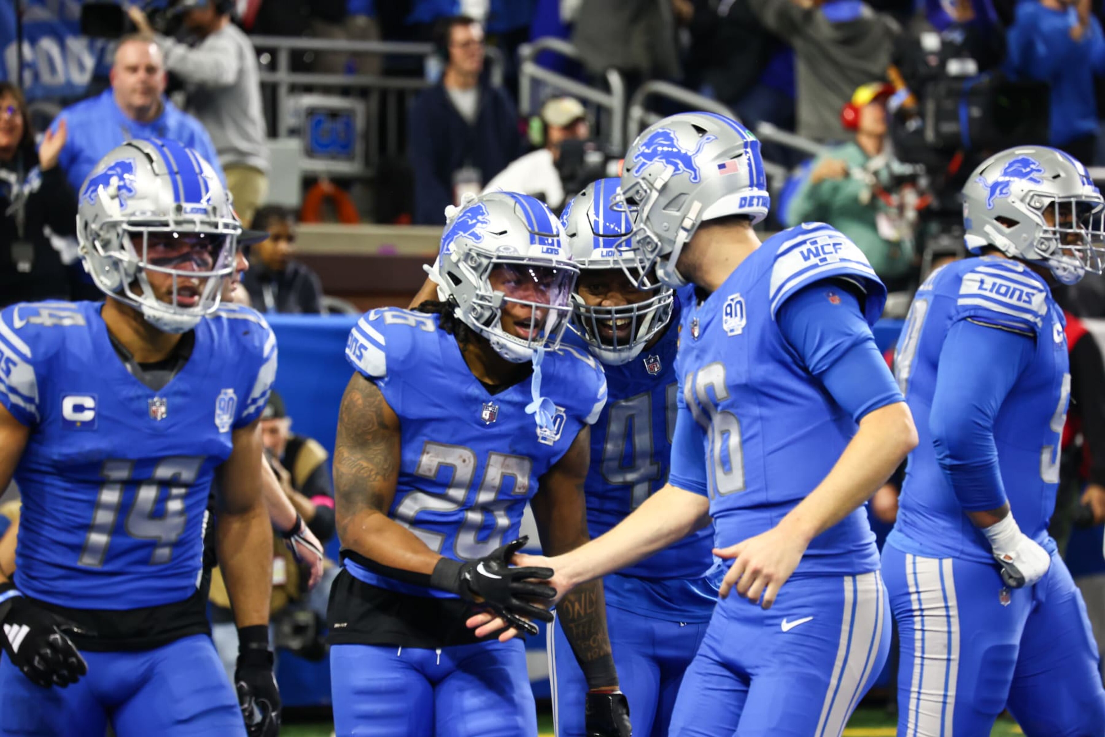 DETROIT, MI - JANUARY 21:  Detroit Lions running back Jahmyr Gibbs (26) is congratulated by Detroit Lions quarterback Jared Goff (16) after scoring a touchdown on a running play during an NFL NFC Divisional playoff football game between the Tampa Bay Buccaneers and the Detroit Lions on January 21, 2024 at Ford Field in Detroit, Michigan. (Photo by Scott W. Grau/Icon Sportswire via Getty Images)