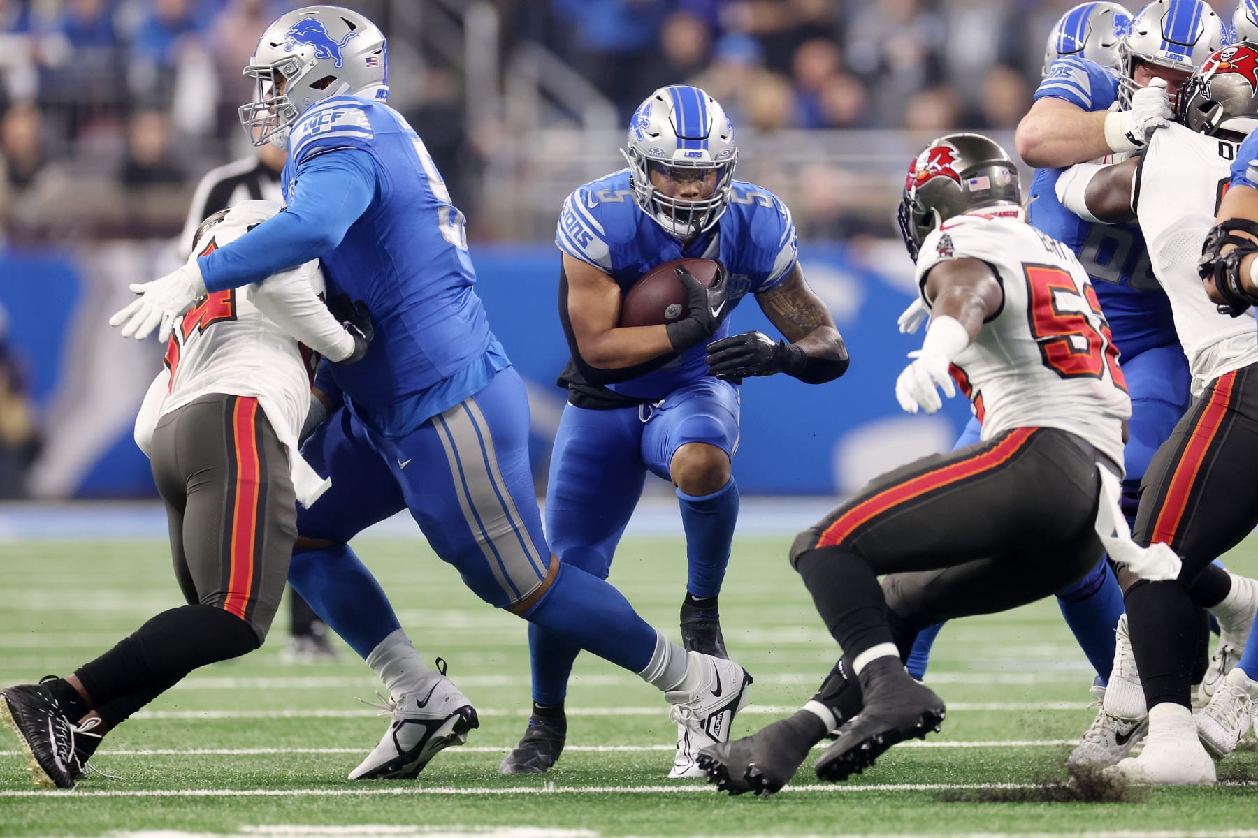 DETROIT, MICHIGAN - JANUARY 21: David Montgomery #5 of the Detroit Lions is brought down by K.J. Britt #52 of the Tampa Bay Buccaneers during the first quarter of the NFC Divisional Playoff game at Ford Field on January 21, 2024 in Detroit, Michigan. (Photo by Gregory Shamus/Getty Images)