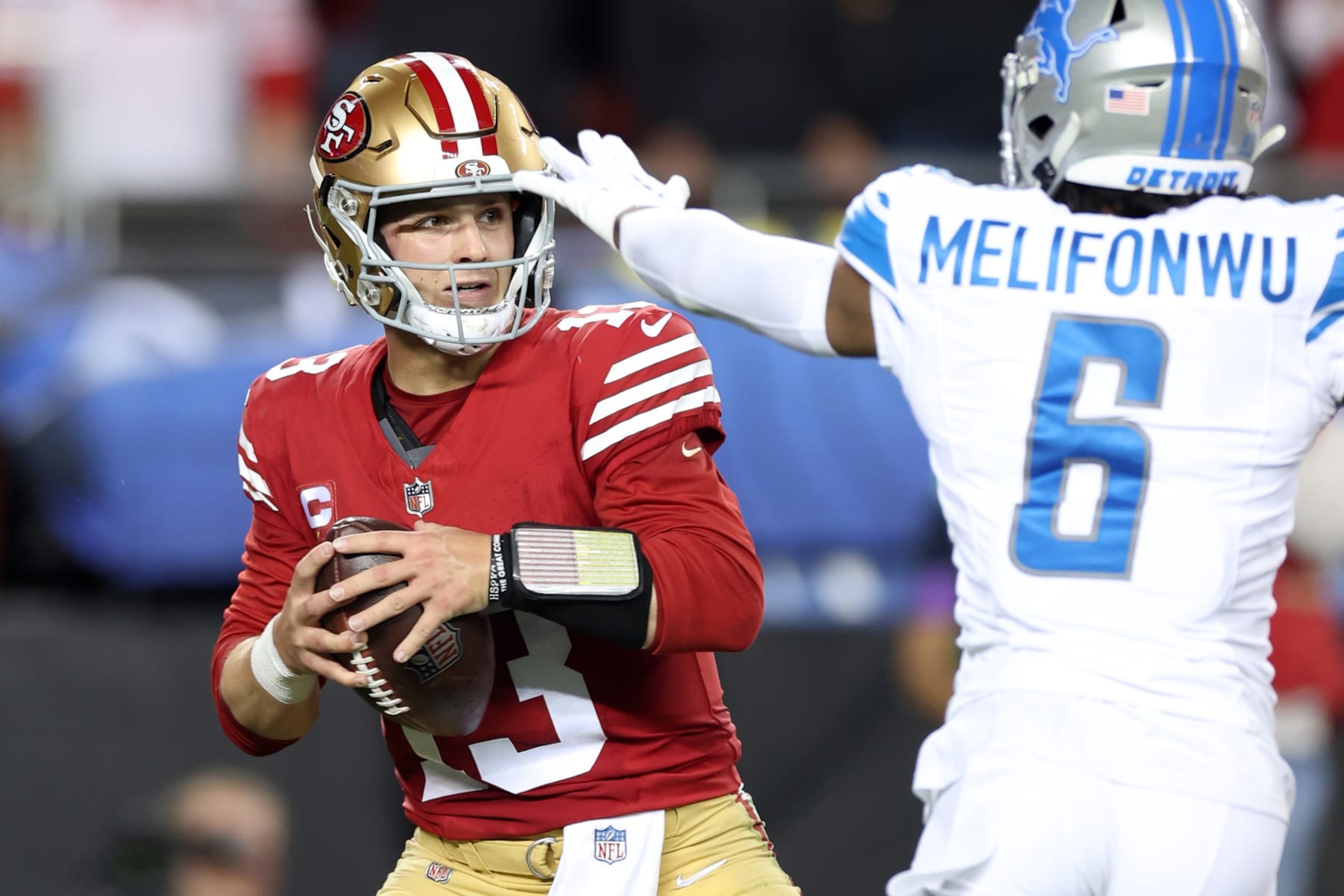 SANTA CLARA, CALIFORNIA - JANUARY 28: Brock Purdy #13 of the San Francisco 49ers looks to throw the ball while under pressure by Ifeatu Melifonwu #6 of the Detroit Lions during the second half in the NFC Championship Game at Levi's Stadium on January 28, 2024 in Santa Clara, California. (Photo by Ezra Shaw/Getty Images)
