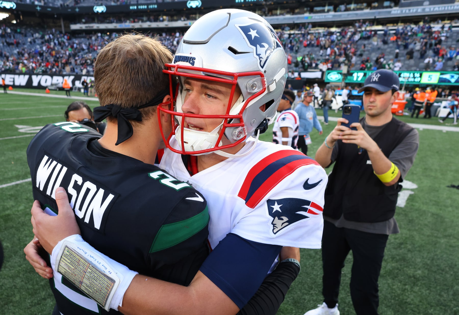 EAST RUTHERFORD, NEW JERSEY - OCTOBER 30: Mac Jones #10 of the New England Patriots and Zach Wilson #2 of the New York Jets hug after a game at MetLife Stadium on October 30, 2022 in East Rutherford, New Jersey. (Photo by Mike Stobe/Getty Images)
