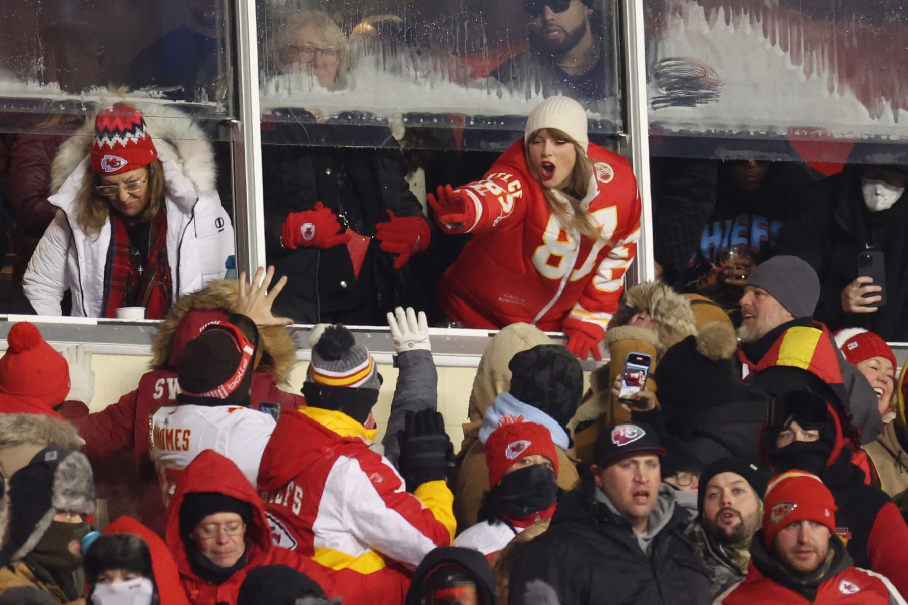 KANSAS CITY, MISSOURI - JANUARY 13: Taylor Swift celebrates with fans during the AFC Wild Card Playoffs between the Miami Dolphins and the Kansas City Chiefs at GEHA Field at Arrowhead Stadium on January 13, 2024 in Kansas City, Missouri. (Photo by Jamie Squire/Getty Images)