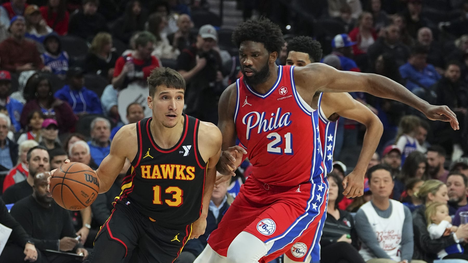PHILADELPHIA, PENNSYLVANIA - DECEMBER 8: Bogdan Bogdanovic #13 of the Atlanta Hawks drives to the basket against Joel Embiid #21 of the Philadelphia 76ers at the Wells Fargo Center on December 8, 2023 in Philadelphia, Pennsylvania. NOTE TO USER: User expressly acknowledges and agrees that, by downloading and or using this photograph, User is consenting to the terms and conditions of the Getty Images License Agreement. (Photo by Mitchell Leff/Getty Images)