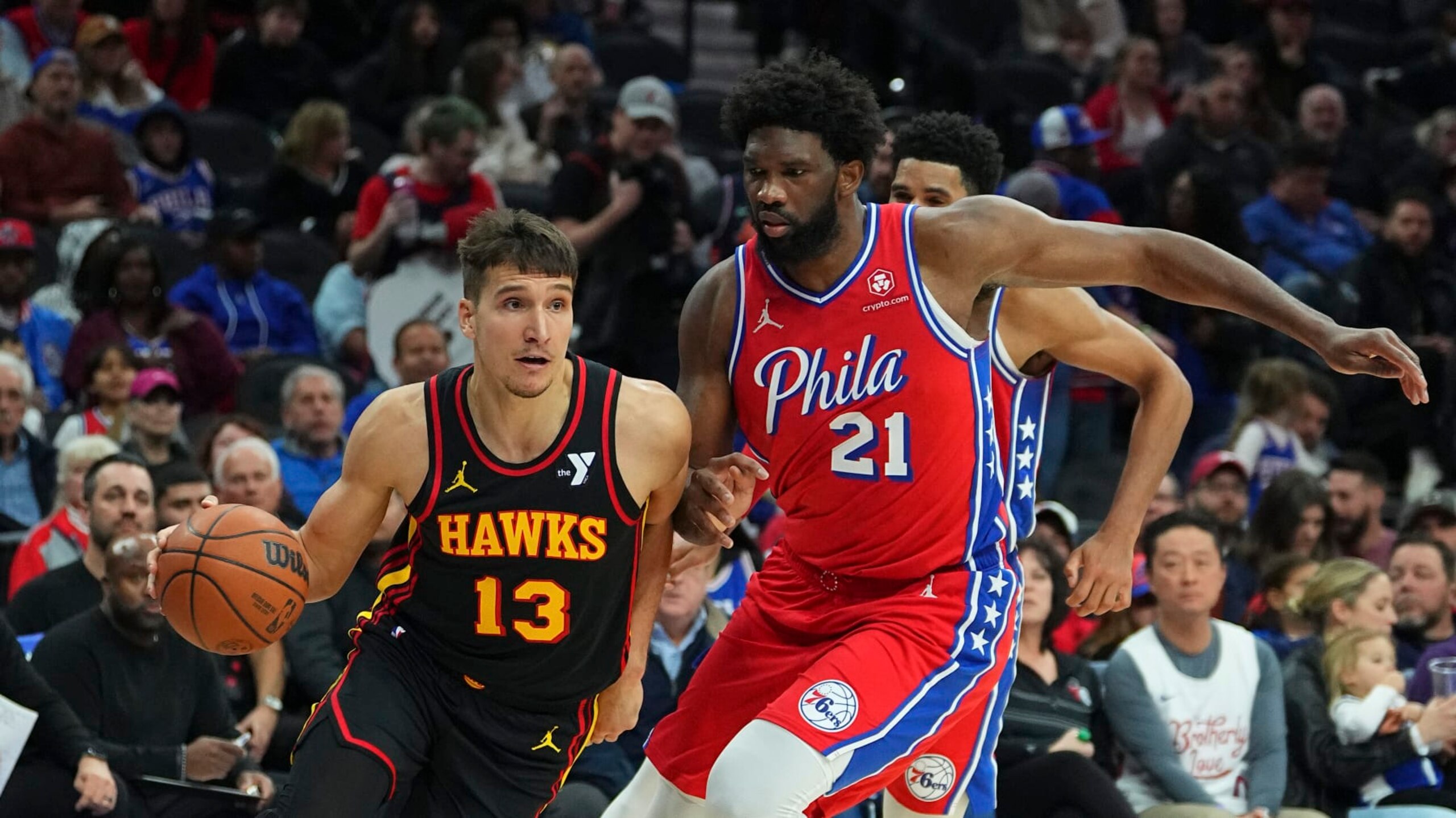 PHILADELPHIA, PENNSYLVANIA - DECEMBER 8: Bogdan Bogdanovic #13 of the Atlanta Hawks drives to the basket against Joel Embiid #21 of the Philadelphia 76ers at the Wells Fargo Center on December 8, 2023 in Philadelphia, Pennsylvania. NOTE TO USER: User expressly acknowledges and agrees that, by downloading and or using this photograph, User is consenting to the terms and conditions of the Getty Images License Agreement. (Photo by Mitchell Leff/Getty Images)