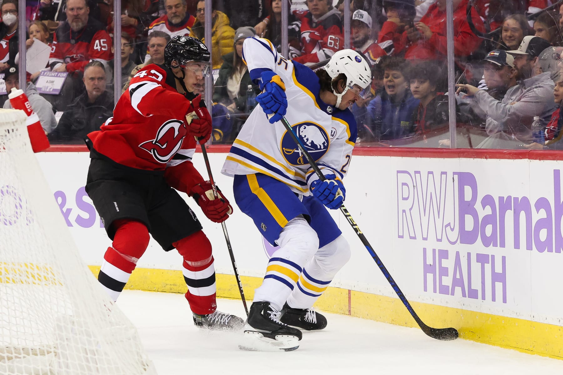 NEWARK, NJ - NOVEMBER 25: New Jersey Devils defenseman Luke Hughes (43) and Buffalo Sabres defenseman Owen Power (25) battle for a puck during a game between the Buffalo Sabres and New Jersey Devils on November 25, 2023 at Prudential Center in the Newark, New Jersey.(Photo by Andrew Mordzynski/Icon Sportswire via Getty Images)