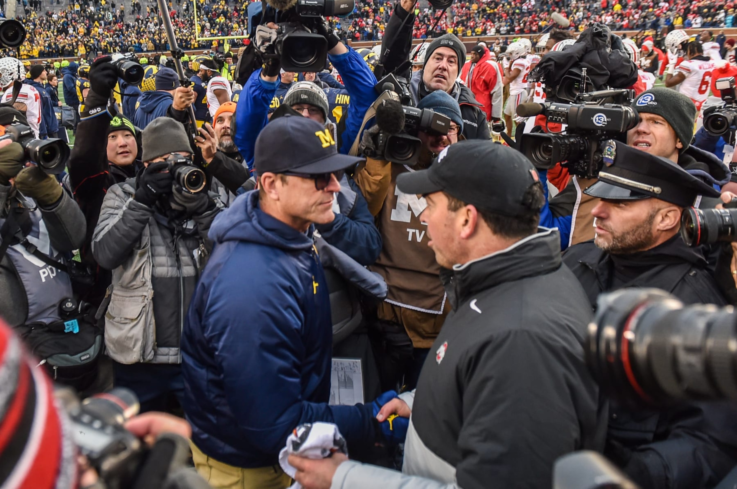 ANN ARBOR, MICHIGAN - NOVEMBER 30: Head Coach Ryan Day (R) of the Ohio State Buckeyes shakes hands with Head Coach Jim Harbaugh (L) of the Michigan Wolverines after a college football game at Michigan Stadium on November 30, 2019 in Ann Arbor, MI. The Ohio State Buckeyes won the game 56-27 over the Michigan Wolverines. (Photo by Aaron J. Thornton/Getty Images) ANN ARBOR, MICHIGAN - NOVEMBER 30: Head Coach Ryan Day (R) of the Ohio State Buckeyes shakes hands with Head Coach Jim Harbaugh (L) of the Michigan Wolverines after a college football game at Michigan Stadium on November 30, 2019 in Ann Arbor, MI. The Ohio State Buckeyes won the game 56-27 over the Michigan Wolverines. (Photo by Aaron J. Thornton/Getty Images)