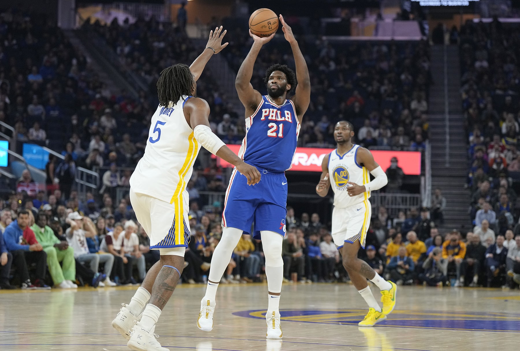 SAN FRANCISCO, CALIFORNIA - JANUARY 30: Joel Embiid #21 of the Philadelphia 76ers shoots a three-point shot over Kevon Looney #5 of the Golden State Warriors during the first quarter at Chase Center on January 30, 2024 in San Francisco, California. NOTE TO USER: User expressly acknowledges and agrees that, by downloading and or using this photograph, User is consenting to the terms and conditions of the Getty Images License Agreement. (Photo by Thearon W. Henderson/Getty Images)