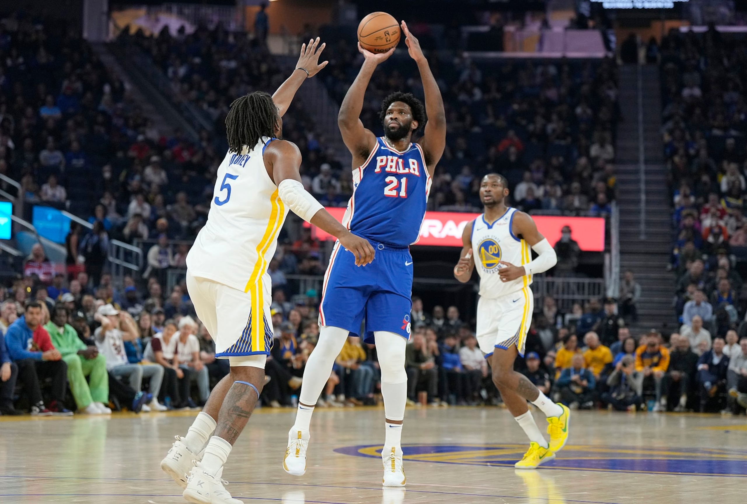 SAN FRANCISCO, CALIFORNIA - JANUARY 30: Joel Embiid #21 of the Philadelphia 76ers shoots a three-point shot over Kevon Looney #5 of the Golden State Warriors during the first quarter at Chase Center on January 30, 2024 in San Francisco, California. NOTE TO USER: User expressly acknowledges and agrees that, by downloading and or using this photograph, User is consenting to the terms and conditions of the Getty Images License Agreement. (Photo by Thearon W. Henderson/Getty Images)