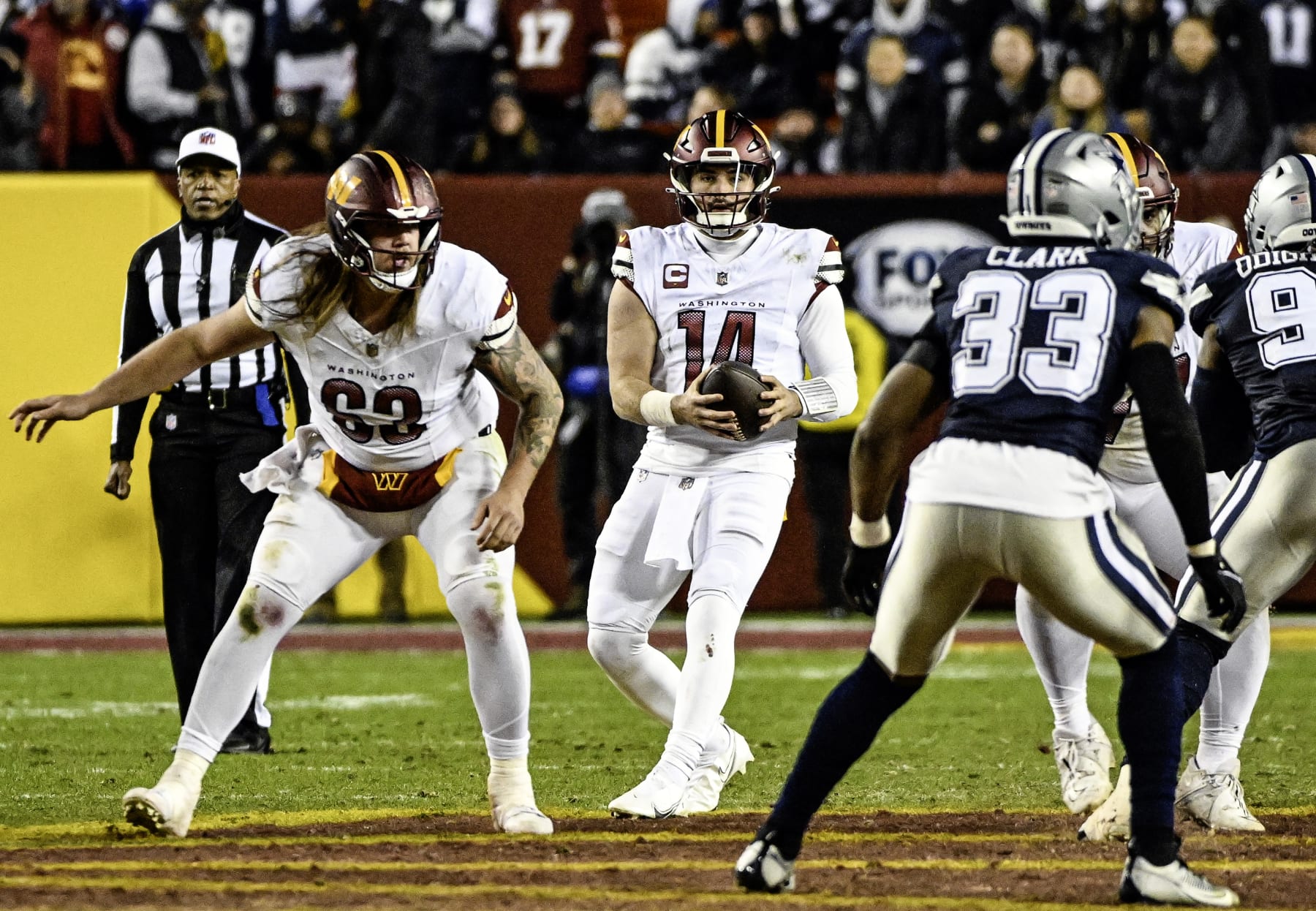 LANDOVER, MD - JANUARY 07: Washington Commanders quarterback Sam Howell (14) drops back with center Nick Gates (63) providing protection during the NFL game between the Dallas Cowboys and the Washington Commanders on January 7, 2024 at FedEx Field in Landover, MD. (Photo by Mark Goldman/Icon Sportswire via Getty Images)