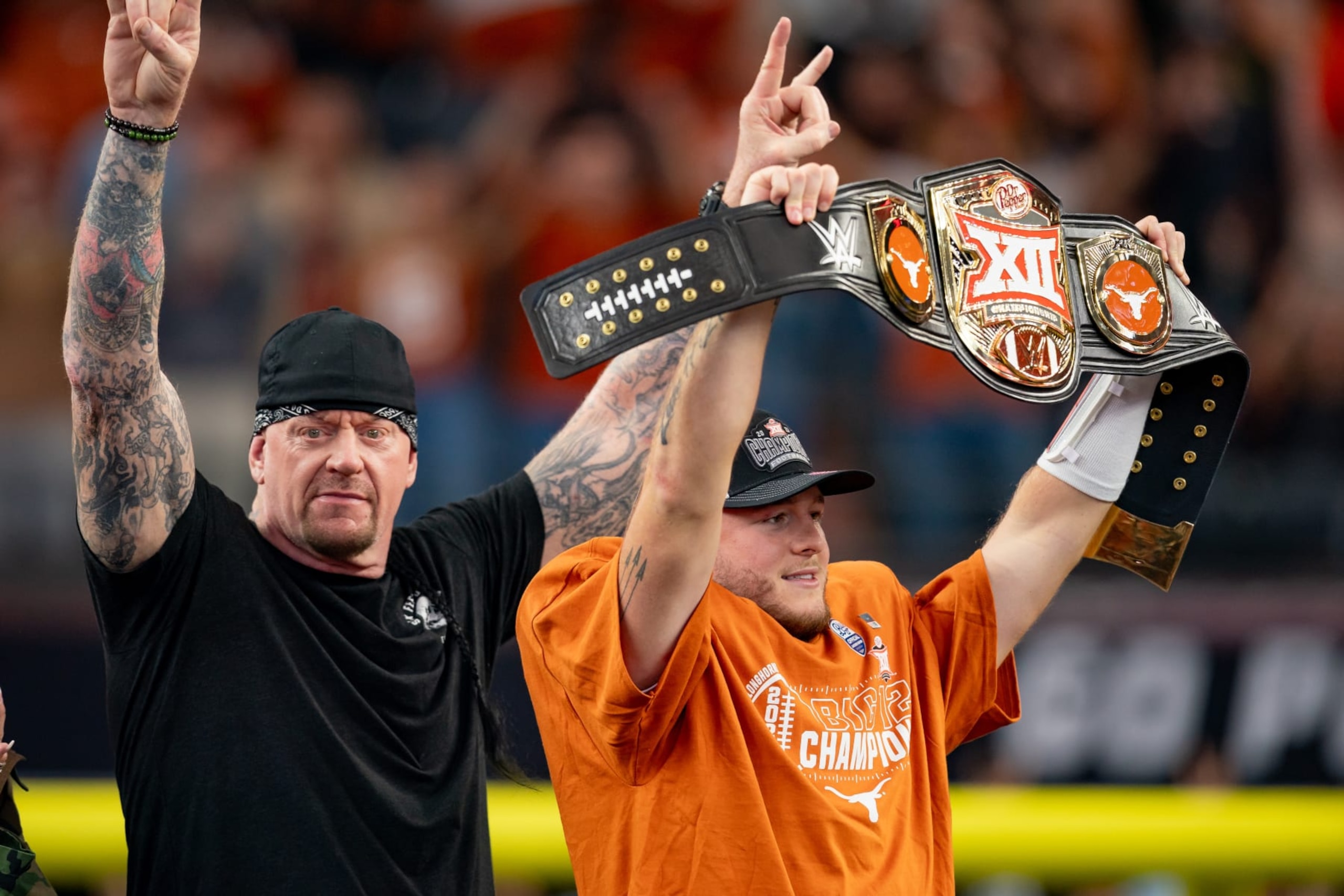 ARLINGTON, TX - DECEMBER 02: Texas Longhorns quarterback Quinn Ewers (3) holds up the WWE Big 12 Championship belt as WWE legend The Undertaker throws horns up after winning the Big 12 Championship game between the Texas Longhorns and the Oklahoma State Cowboys  on December 02, 2023 at AT&T Stadium in Arlington, TX. (Photo by Chris Leduc/Icon Sportswire via Getty Images)