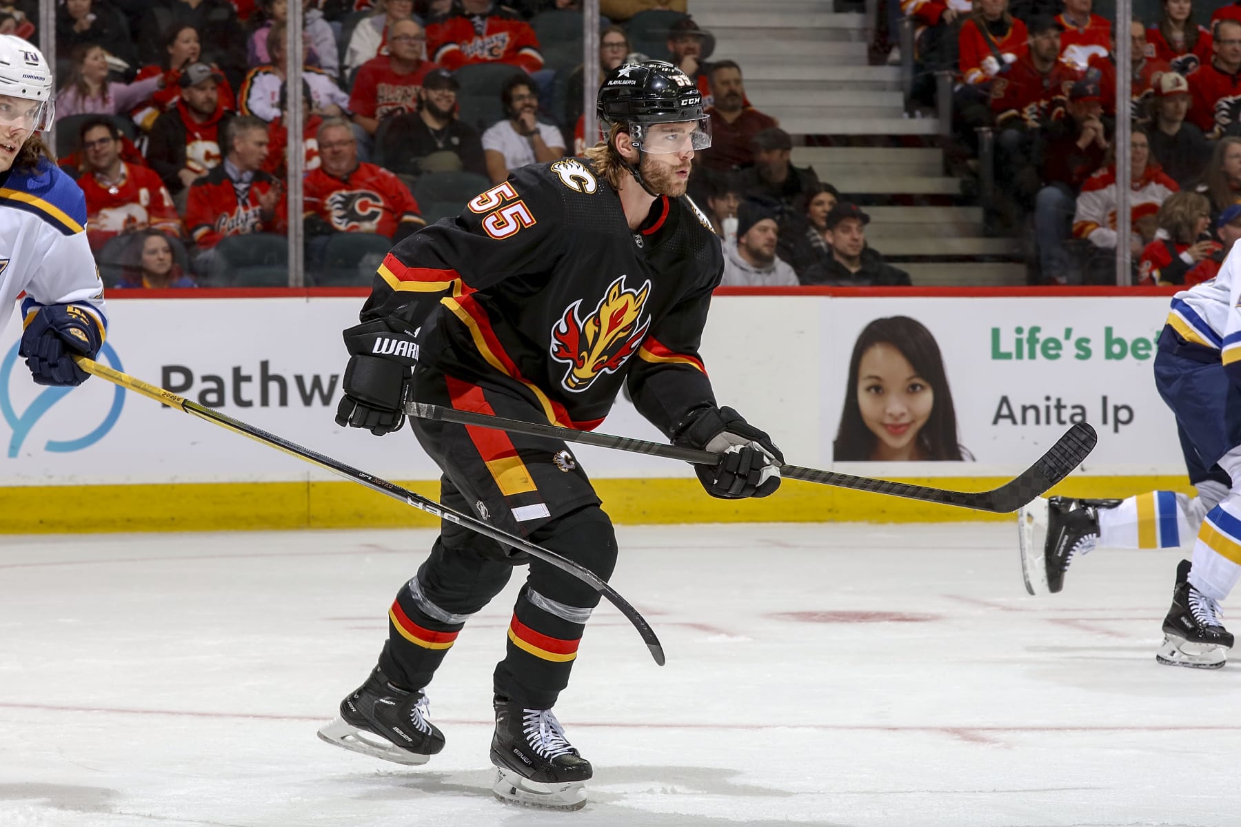 CALGARY, AB - JANUARY 23: Noah Hanifin #55 of the Calgary Flames skates up ice against the St Louis Blues at Scotiabank Saddledome on January 23, 2024 in Calgary, Alberta, Canada. (Photo by Gerry Thomas/NHLI via Getty Images)