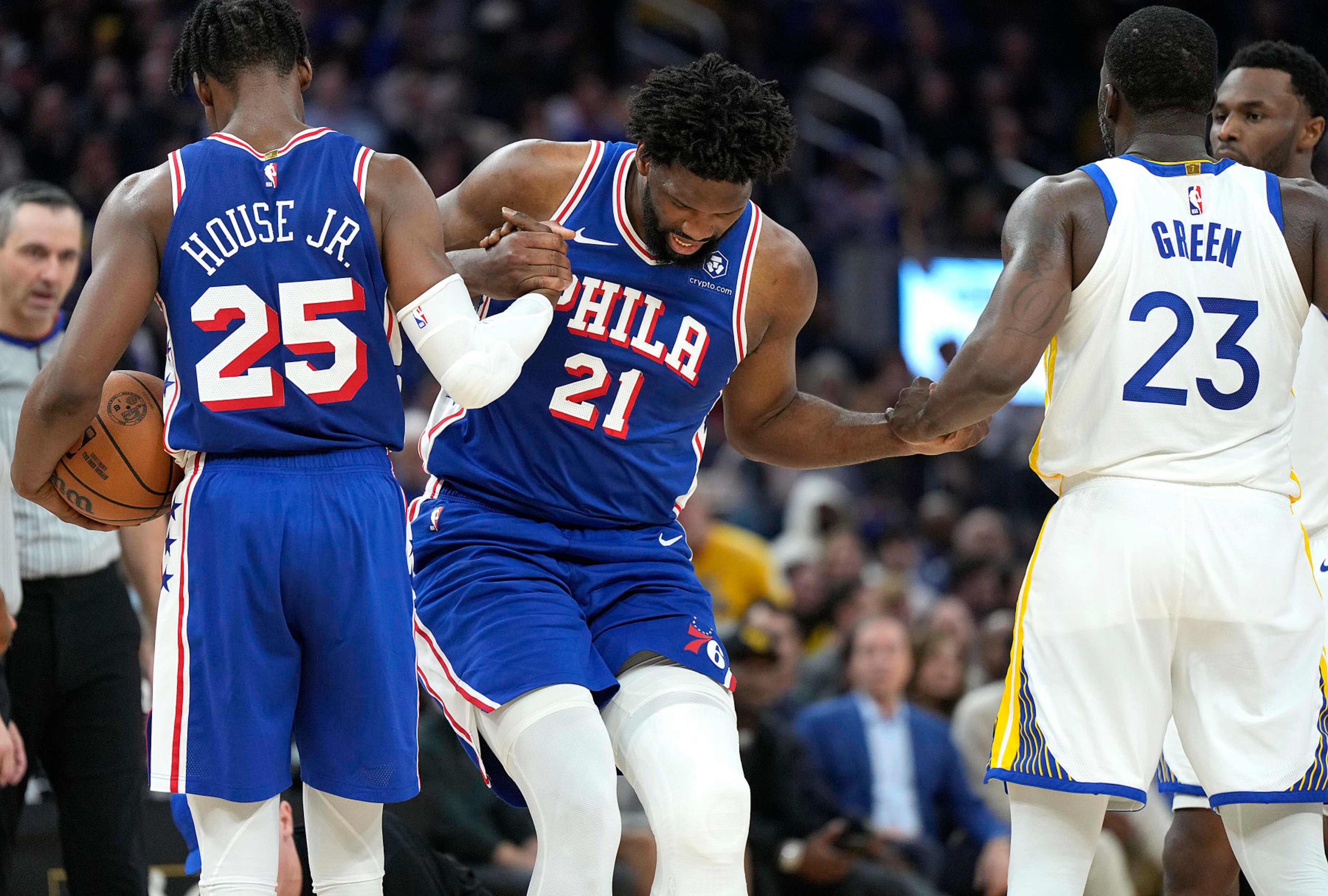 SAN FRANCISCO, CALIFORNIA - JANUARY 30: Joel Embiid #21 of the Philadelphia 76ers gets helped up from the floor by teammate Danuel House Jr. #25 and Draymond Green #23 of the Golden State Warriors during the second quarter at Chase Center on January 30, 2024 in San Francisco, California. NOTE TO USER: User expressly acknowledges and agrees that, by downloading and or using this photograph, User is consenting to the terms and conditions of the Getty Images License Agreement. (Photo by Thearon W. Henderson/Getty Images)