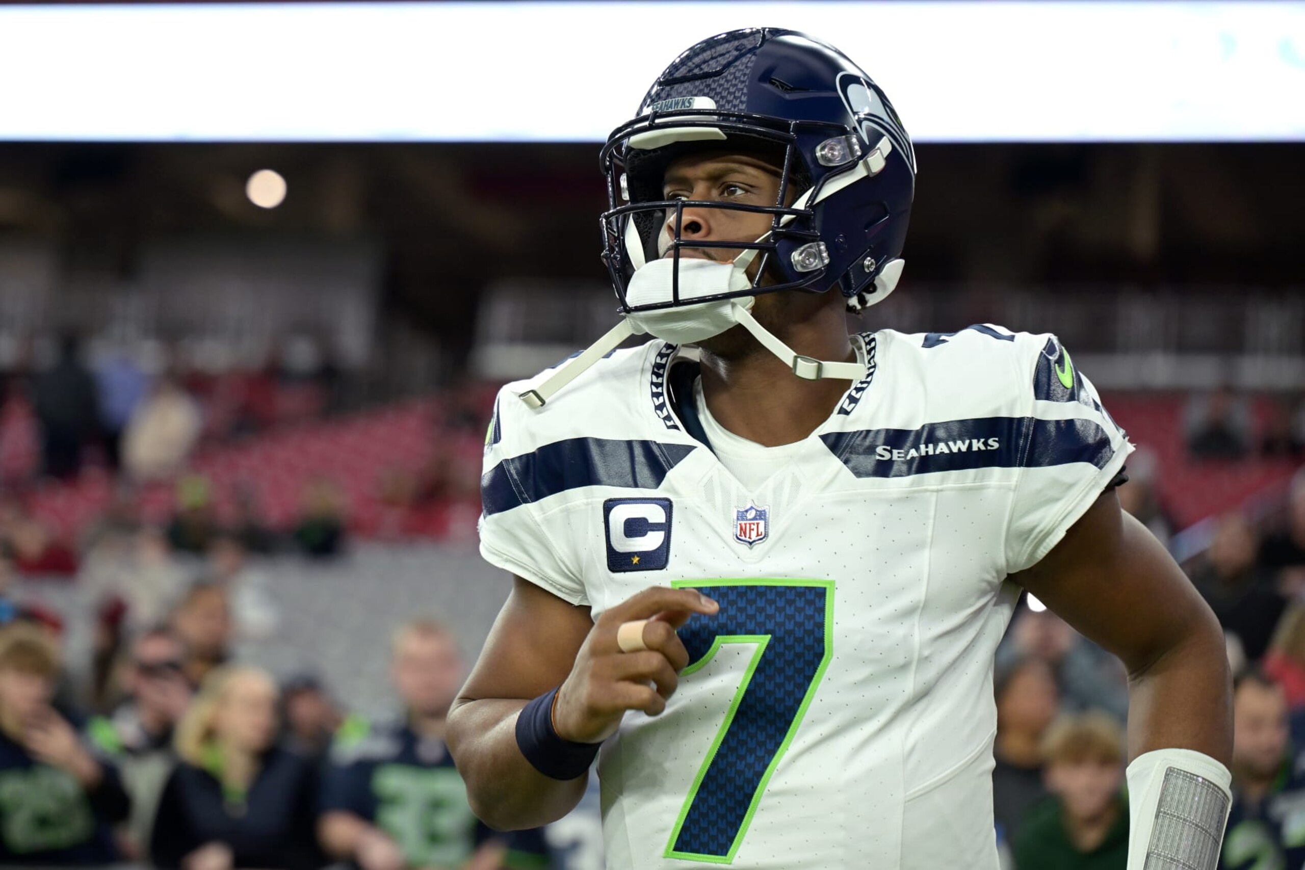 GLENDALE, ARIZONA - JANUARY 07: Geno Smith #7 of the Seattle Seahawks runs onto the field before the game against the Arizona Cardinals at State Farm Stadium on January 07, 2024 in Glendale, Arizona. (Photo by Jennifer Stewart/Getty Images)