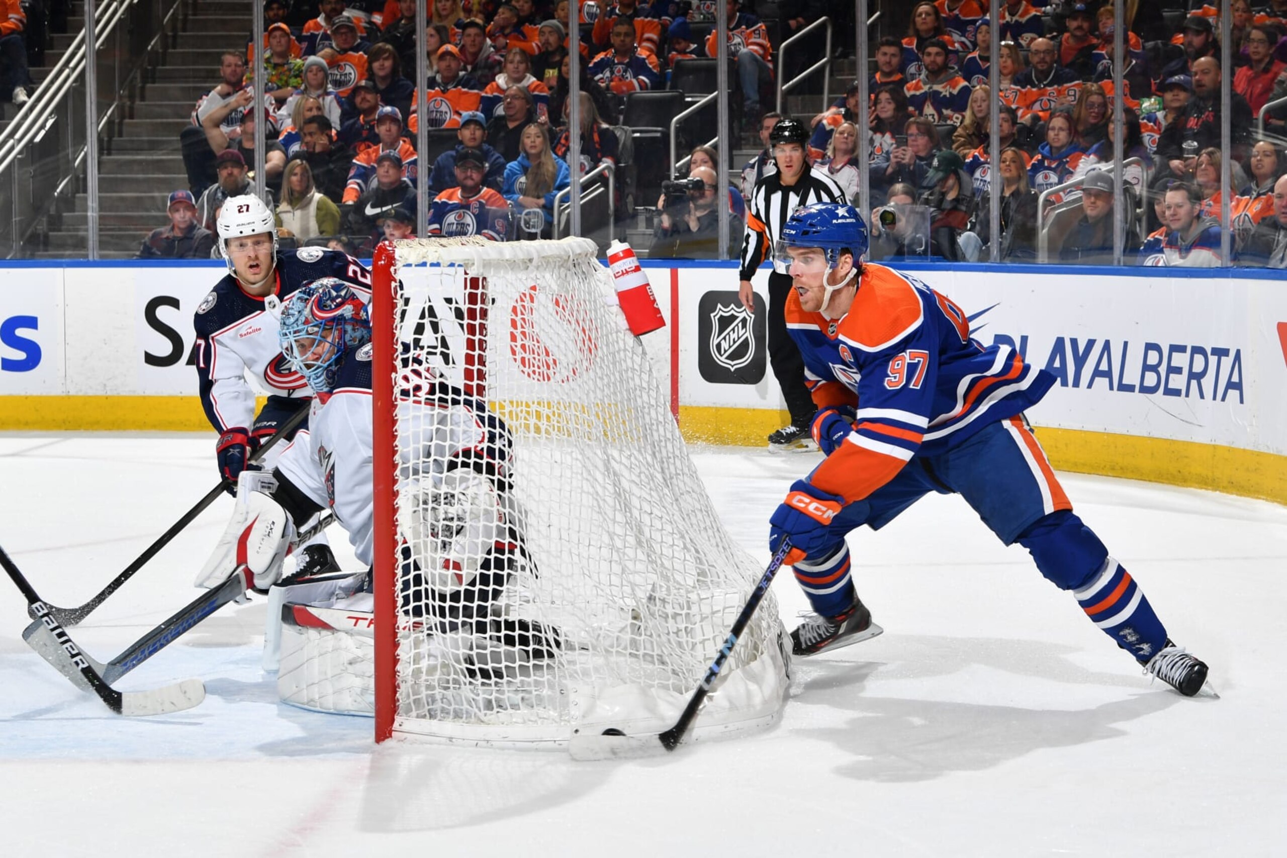 EDMONTON, CANADA - JANUARY 23: Connor McDavid #97 of the Edmonton Oilers skates with the puck behind the net of Elvis Merzlikins #90 of the Columbus Blue Jackets during the game at Rogers Place on January 23, 2024, in Edmonton, Alberta, Canada. (Photo by Andy Devlin/NHLI via Getty Images)