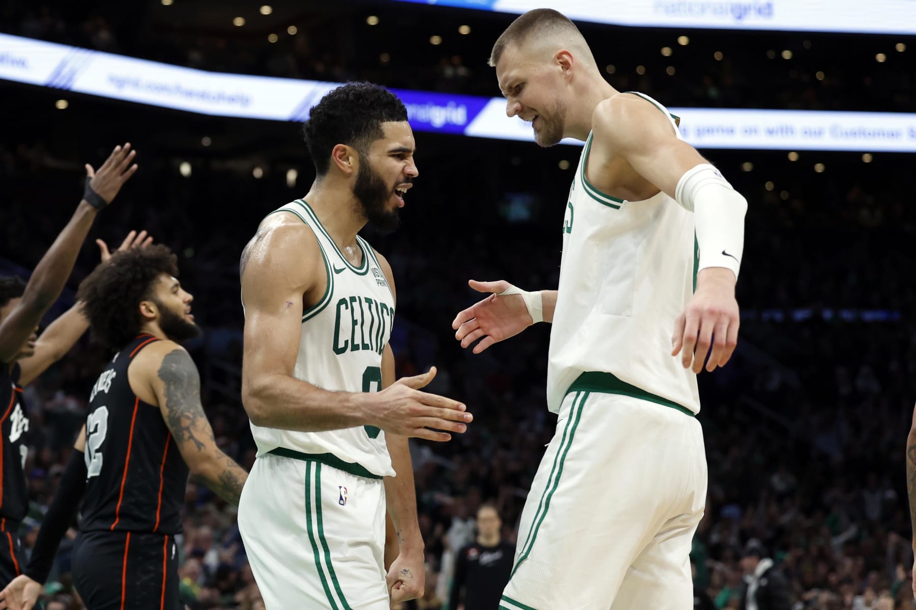 Boston, MA - December 28: Boston Celtics SF Jayson Tatum high fives C Kristaps Porzingis after Tatum was fouled in the second half. The Celtics beat the Detroit Pistons, 128-122, in overtime. (Photo by Danielle Parhizkaran/The Boston Globe via Getty Images)