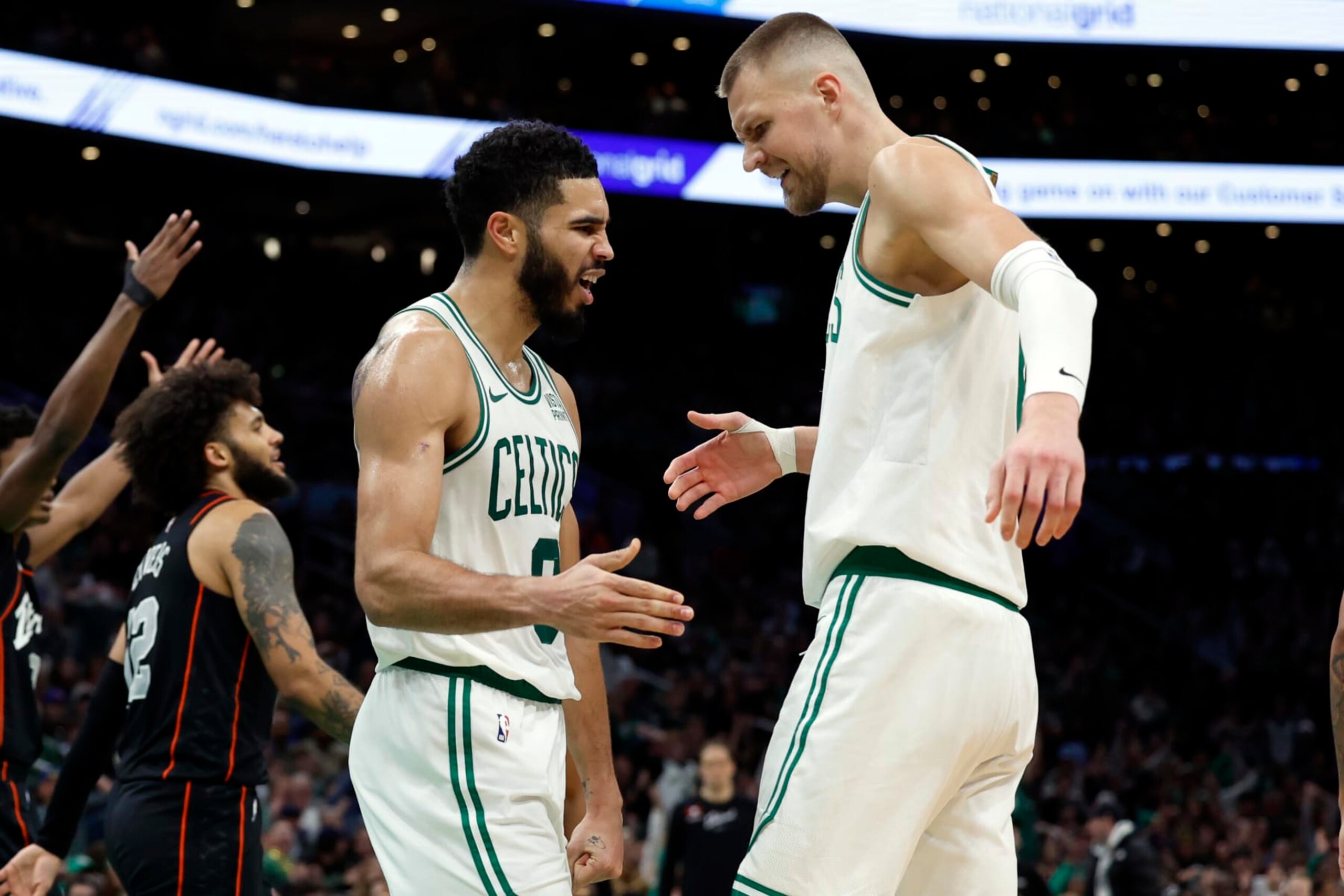 Boston, MA - December 28: Boston Celtics SF Jayson Tatum high fives C Kristaps Porzingis after Tatum was fouled in the second half. The Celtics beat the Detroit Pistons, 128-122, in overtime. (Photo by Danielle Parhizkaran/The Boston Globe via Getty Images)