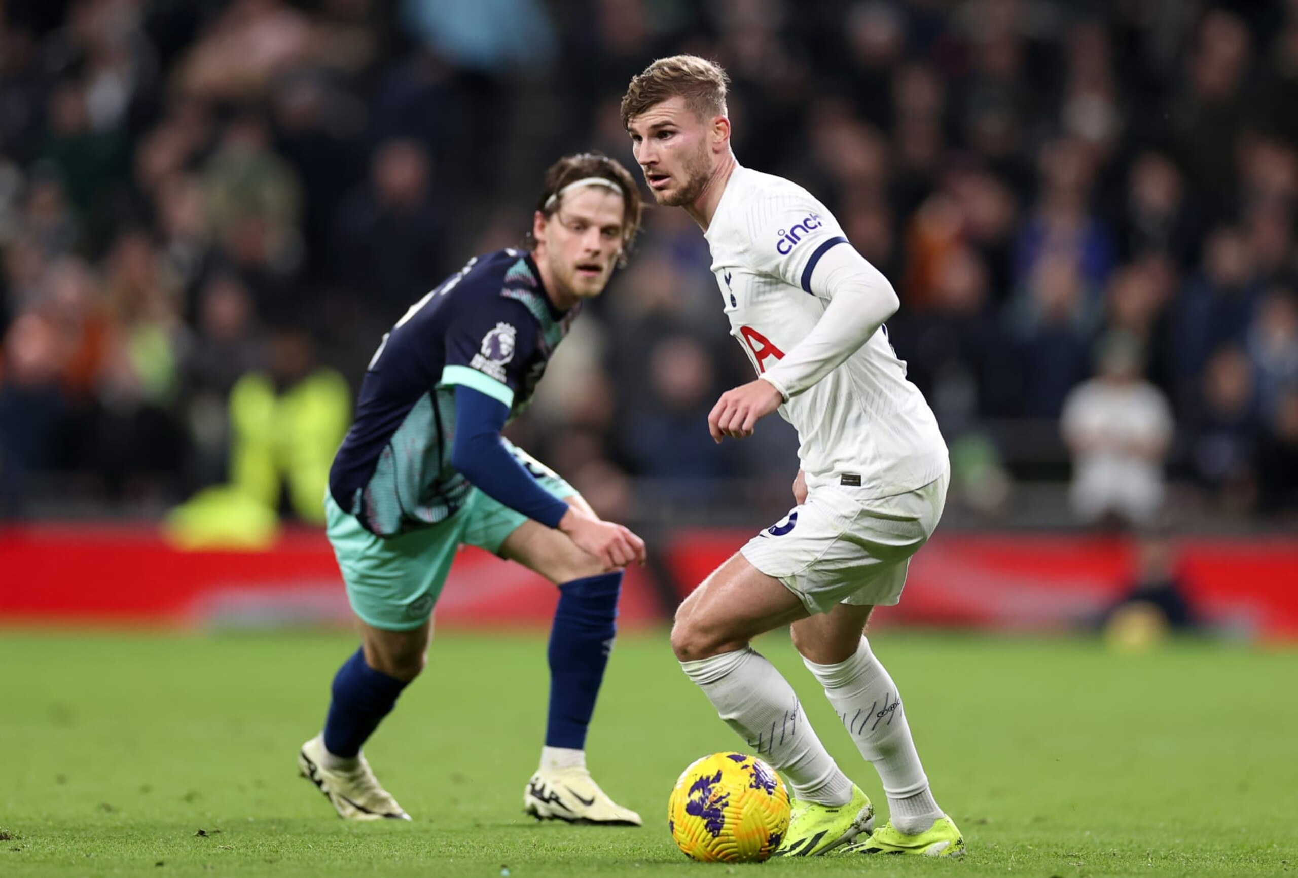 LONDON, ENGLAND - JANUARY 31:  Timo Werner of Tottenham Hotspur runs with the ball whilst under pressure from Mathias Jensen of Brentford during the Premier League match between Tottenham Hotspur and Brentford FC at Tottenham Hotspur Stadium on January 31, 2024 in London, England. (Photo by Ryan Pierse/Getty Images)