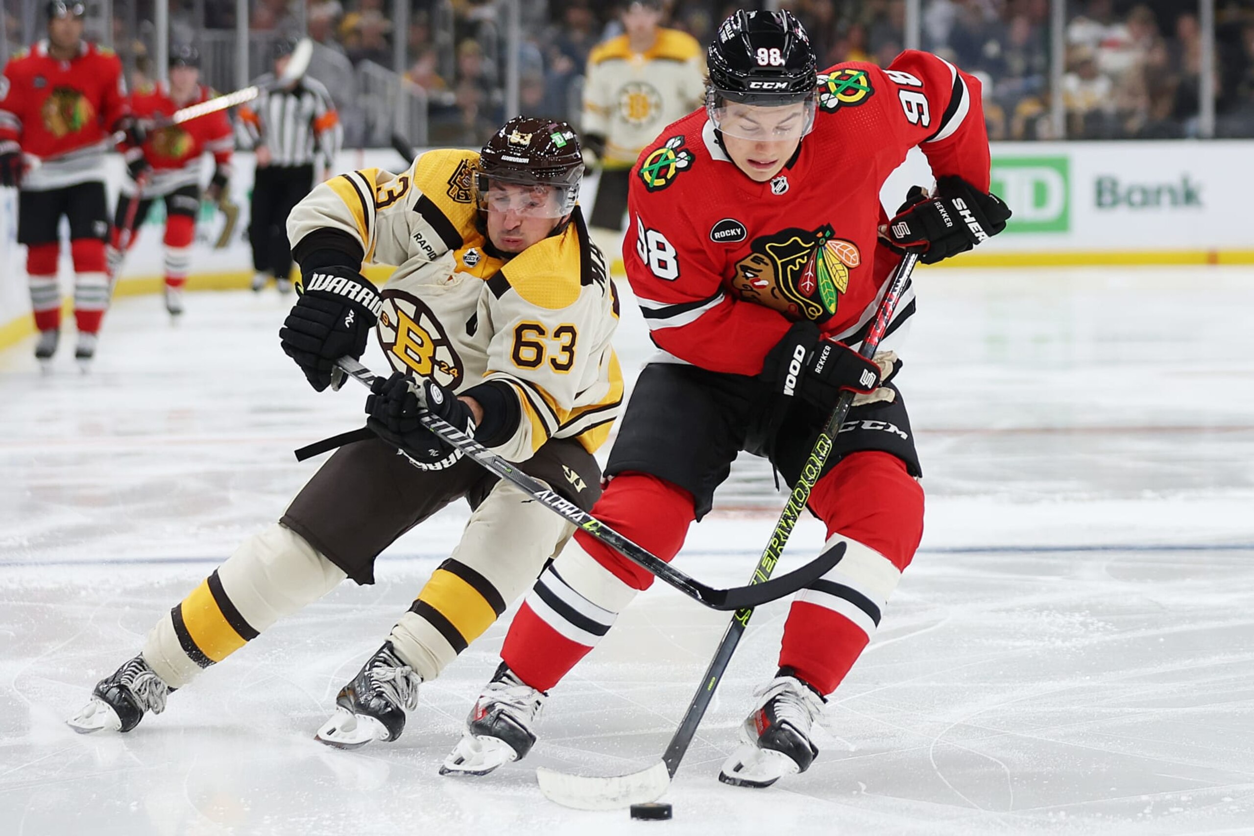 BOSTON, MASSACHUSETTS - OCTOBER 11: Brad Marchand #63 of the Boston Bruins and Connor Bedard #98 of the Chicago Blackhawks battle for control of the puck during the third period of the Bruins home opener at TD Garden on October 11, 2023 in Boston, Massachusetts. The Bruins defeat the Blackhawks 3-1.  (Photo by Maddie Meyer/Getty Images)