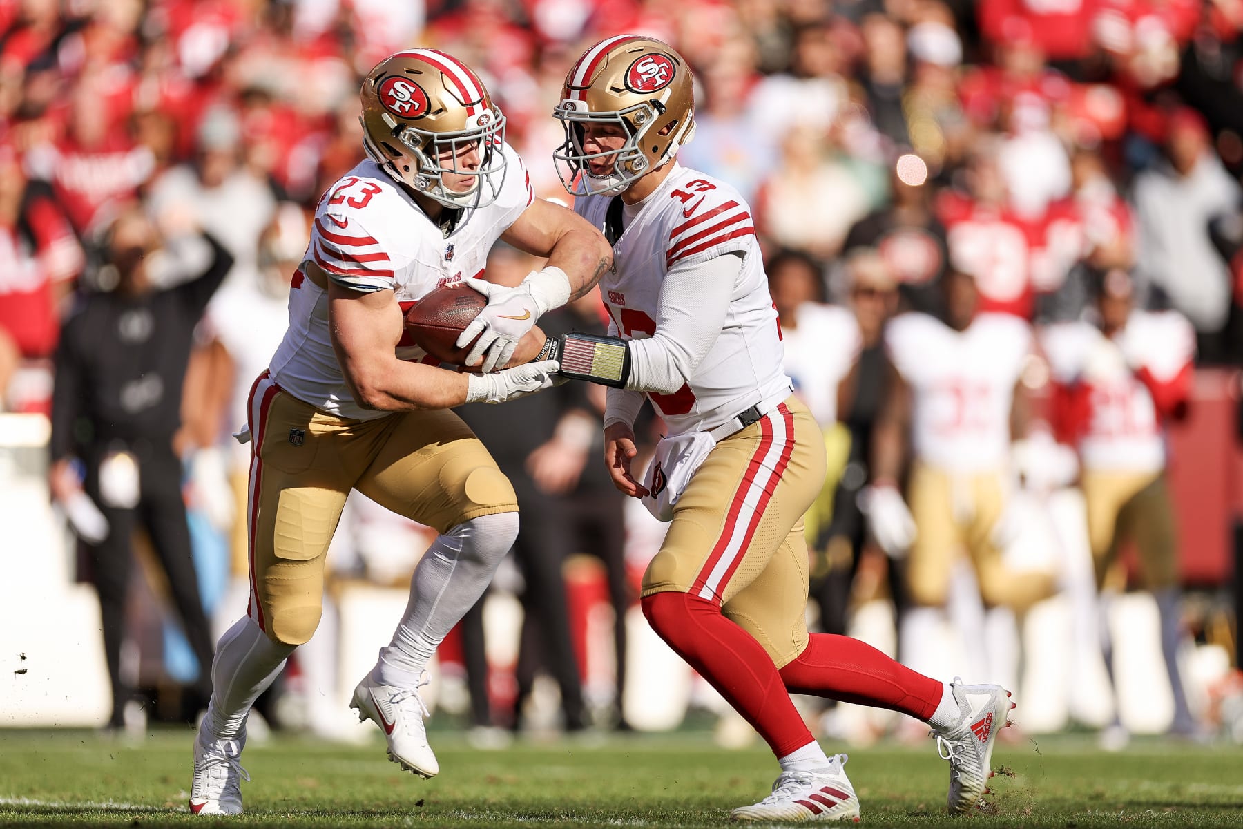 LANDOVER, MARYLAND - DECEMBER 31: Brock Purdy #13  hands the ball off to Christian McCaffrey #23 of the San Francisco 49ers during the first quarter of a game against the Washington Commanders at FedExField on December 31, 2023 in Landover, Maryland. (Photo by Scott Taetsch/Getty Images)