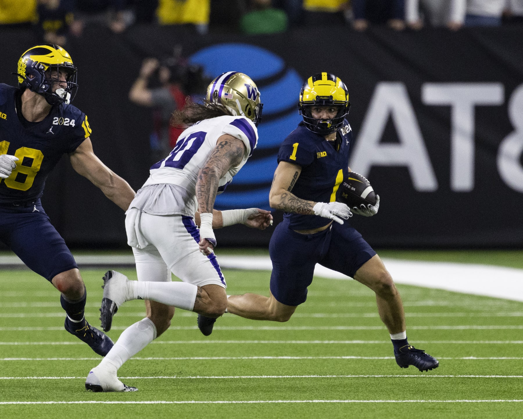 HOUSTON, TX - JANUARY 08: Roman Wilson #1 of the Michigan Wolverines tries to get around Asa Turner #20 of the Washington Huskies between University of Washington and University of Michigan at NRG Stadium on January 8, 2024 in Houston, Texas. (Photo by Steve Limentani/ISI Photos/Getty Images)