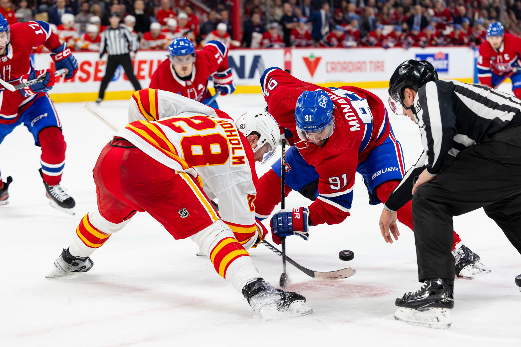 MONTREAL, CANADA - NOVEMBER 14: Elias Lindholm #28 of the Calgary Flames and Sean Monahan #91 of the Montreal Canadiens face-off during the third period of the NHL regular season game at the Bell Centre on November 14, 2023 in Montreal, Quebec, Canada. The Vancouver Canucks defeated the Montreal Canadiens by a score of 5-2. (Photo by Vitor Munhoz/NHLI via Getty Images)