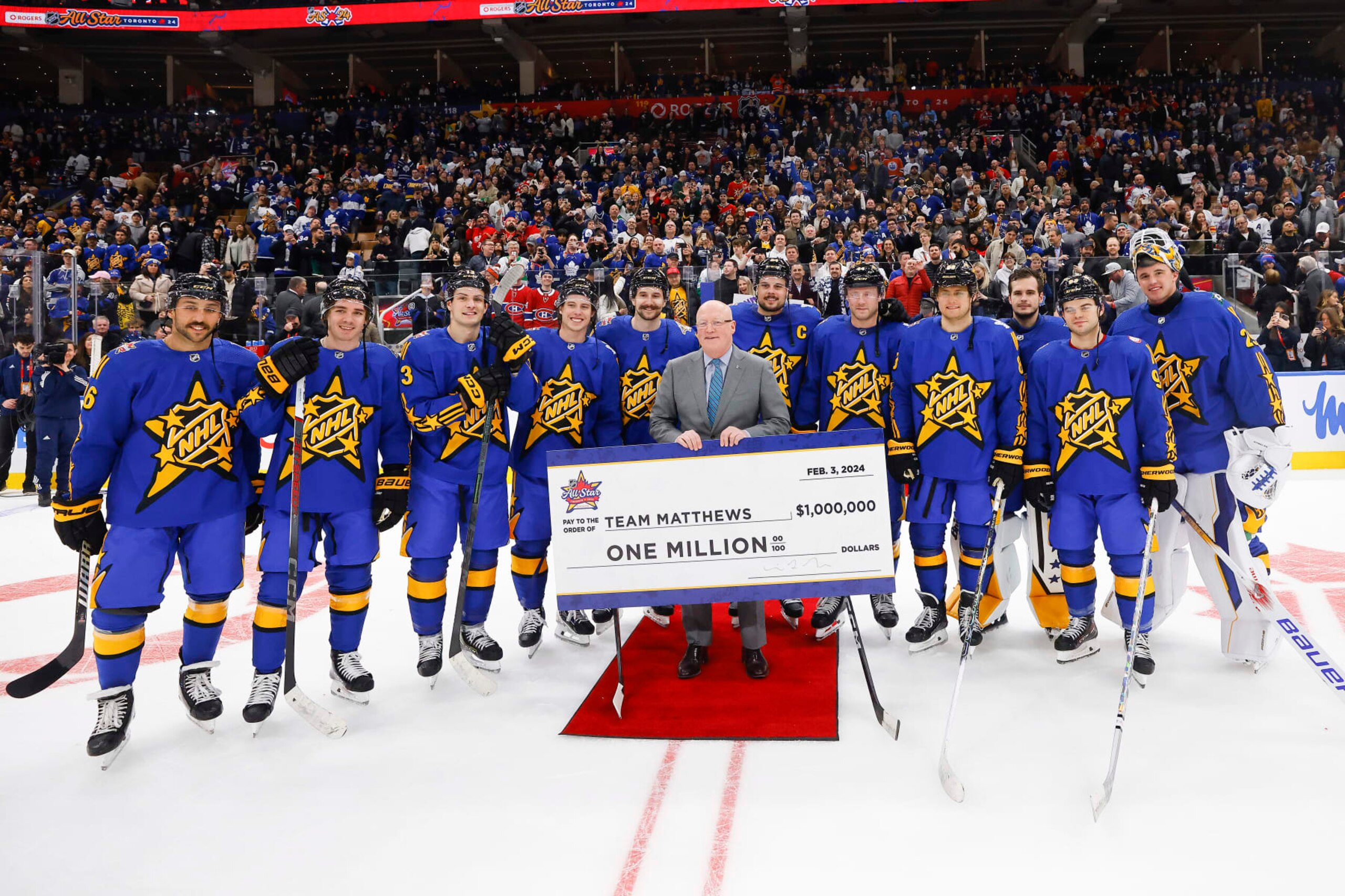 TORONTO, ONTARIO - FEBRUARY 03: Team Matthews is presented a cheque for one million dollars from NHL deputy commissioner Bill Daly during the game between Team Matthews and Team McDavid during the 2024 Honda NHL All-Star Game on February 03, 2024 in Toronto, Ontario. (Photo by Bruce Bennett/Getty Images)