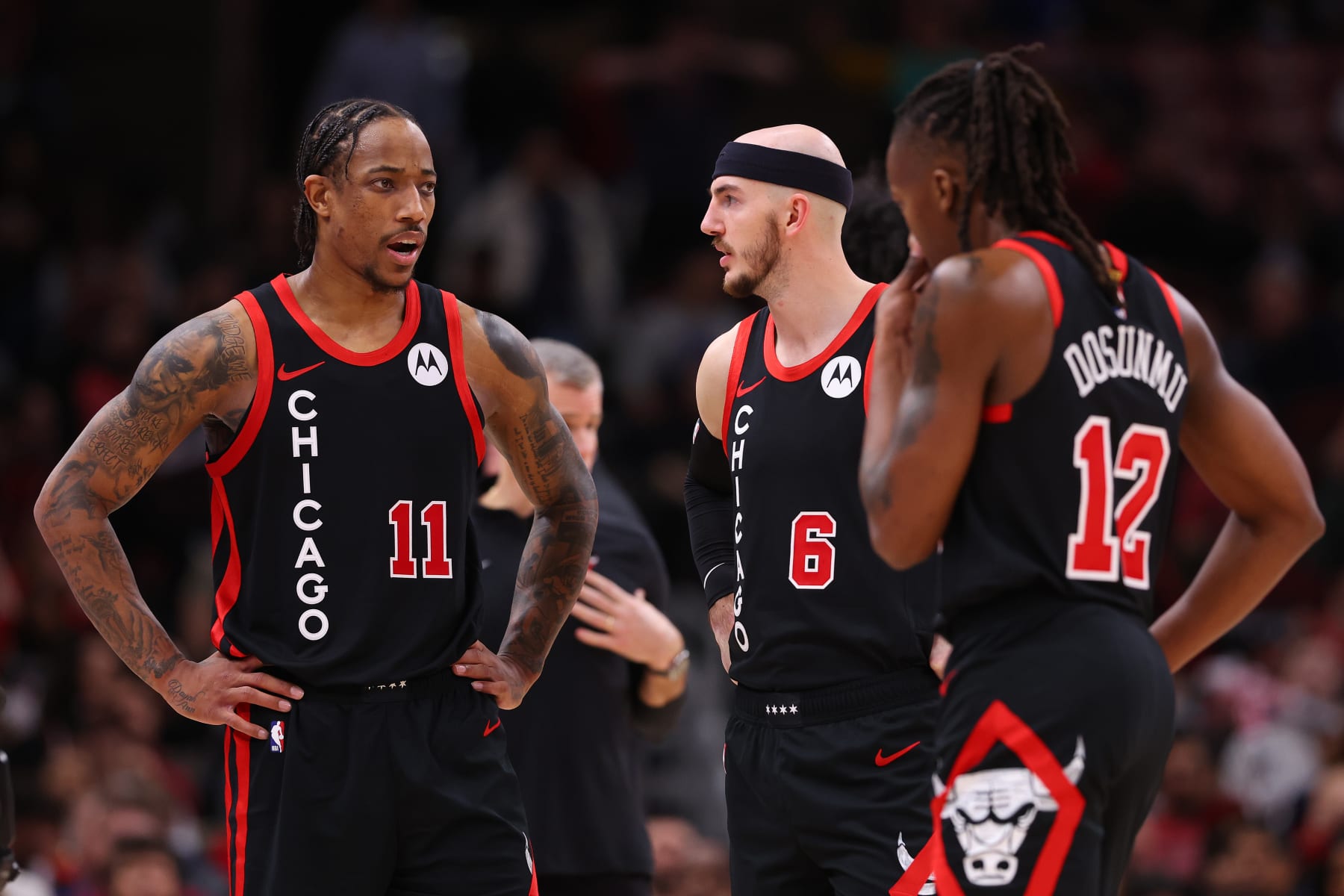 CHICAGO, ILLINOIS - JANUARY 30: DeMar DeRozan #11 of the Chicago Bulls confers with Alex Caruso #6 and Ayo Dosunmu #12 against the Toronto Raptors during the second half at the United Center on January 30, 2024 in Chicago, Illinois. NOTE TO USER: User expressly acknowledges and agrees that, by downloading and or using this photograph, User is consenting to the terms and conditions of the Getty Images License Agreement.  (Photo by Michael Reaves/Getty Images)