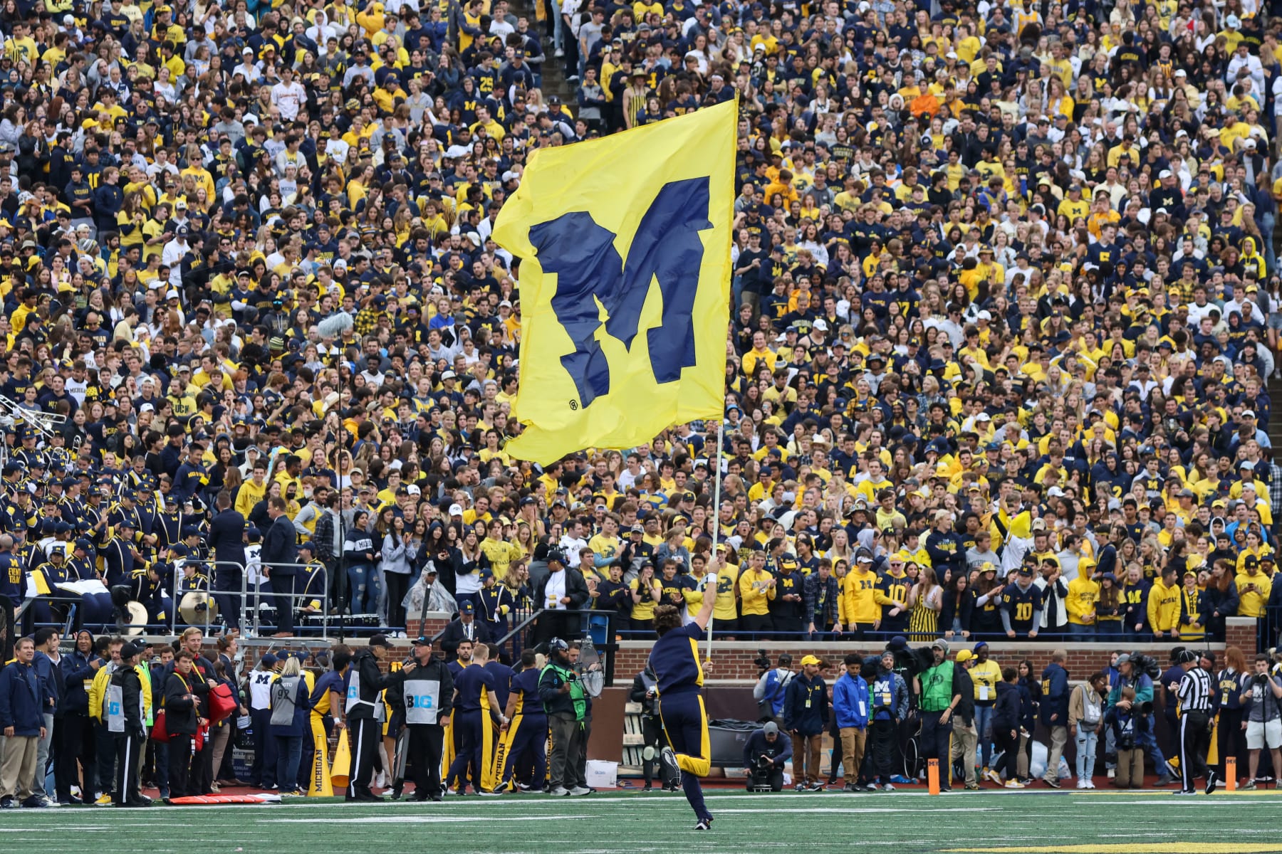 ANN ARBOR, MI - SEPTEMBER 24:  A Michigan cheerleader runs down the field with a flag with the Michigan block "M" logo after Michigan scored a touchdown during the first quarter of a Big Ten Conference regular season college football game between the Maryland Terrapins and the Michigan Wolverines on September 24, 2022 at Michigan Stadium in Ann Arbor, Michigan.  (Photo by Scott W. Grau/Icon Sportswire via Getty Images)