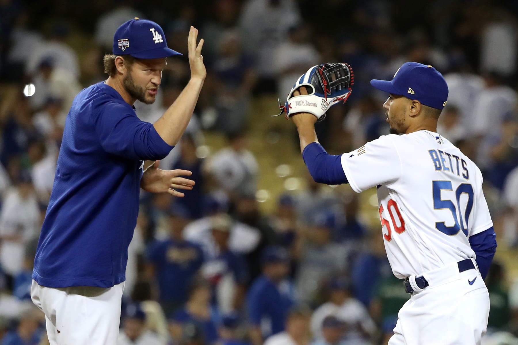 LOS ANGELES, CALIFORNIA - JUNE 15: Clayton Kershaw #22 and Mookie Betts #50 of the Los Angeles Dodgers celebrate their 5-3 win against the Philadelphia Phillies after the game at Dodger Stadium on June 15, 2021 in Los Angeles, California. (Photo by Katelyn Mulcahy/Getty Images)