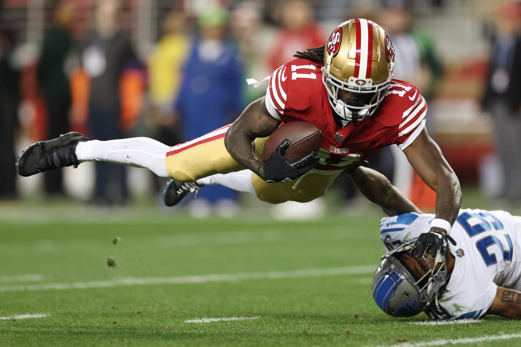 SANTA CLARA, CALIFORNIA - JANUARY 28: Brandon Aiyuk #11 of the San Francisco 49ers catches a pass that was tipped by Kindle Vildor #29 of the Detroit Lions during the third quarter in the NFC Championship Game at Levi's Stadium on January 28, 2024 in Santa Clara, California. (Photo by Ezra Shaw/Getty Images)