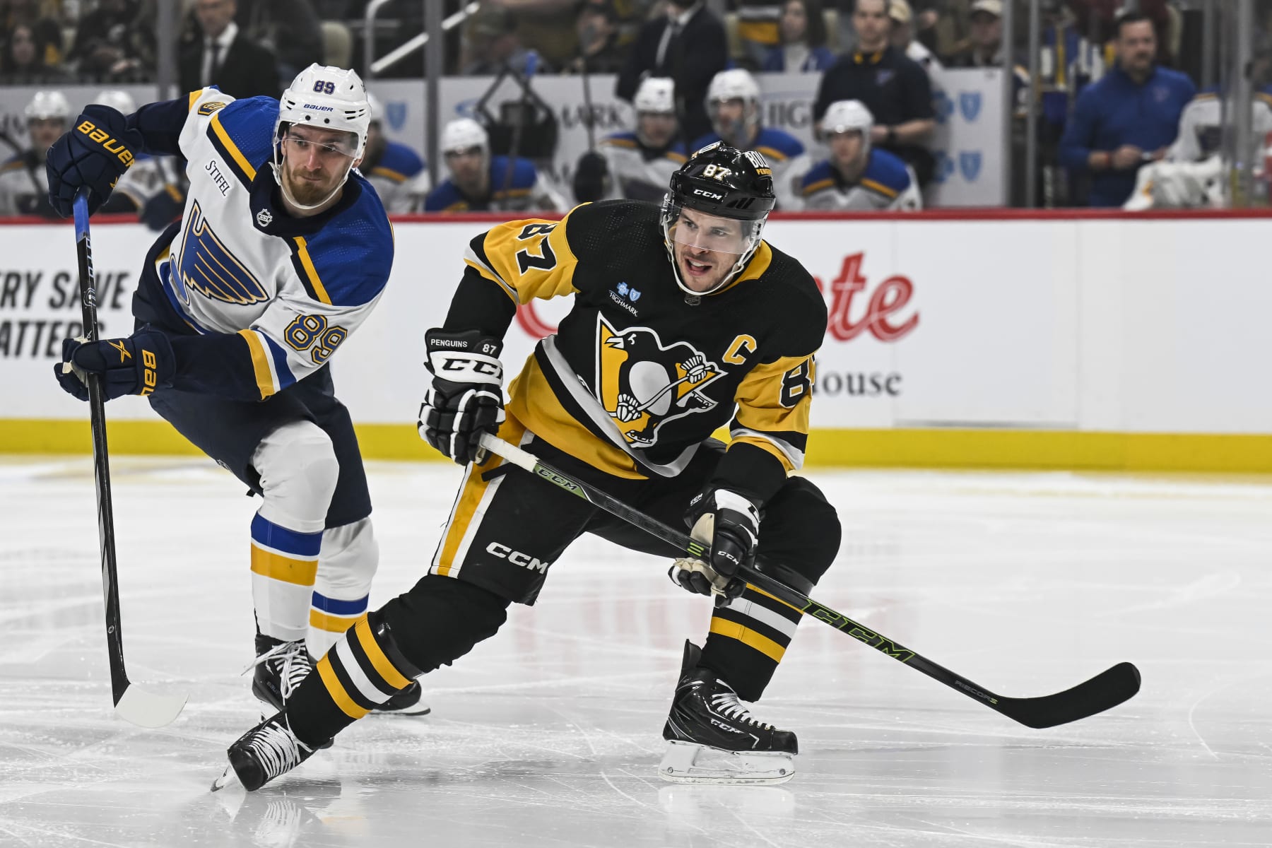 PITTSBURGH, PA - DECEMBER 30: Pittsburgh Penguins center Sidney Crosby (87) looks for a pass as St. Louis Blues left wing Pavel Buchnevich (89) defends during the first period in the NHL game between the Pittsburgh Penguins and the  St. Louis Blues on December 30, 2023, at PPG Paints Arena in Pittsburgh, PA. (Photo by Jeanine Leech/Icon Sportswire via Getty Images)