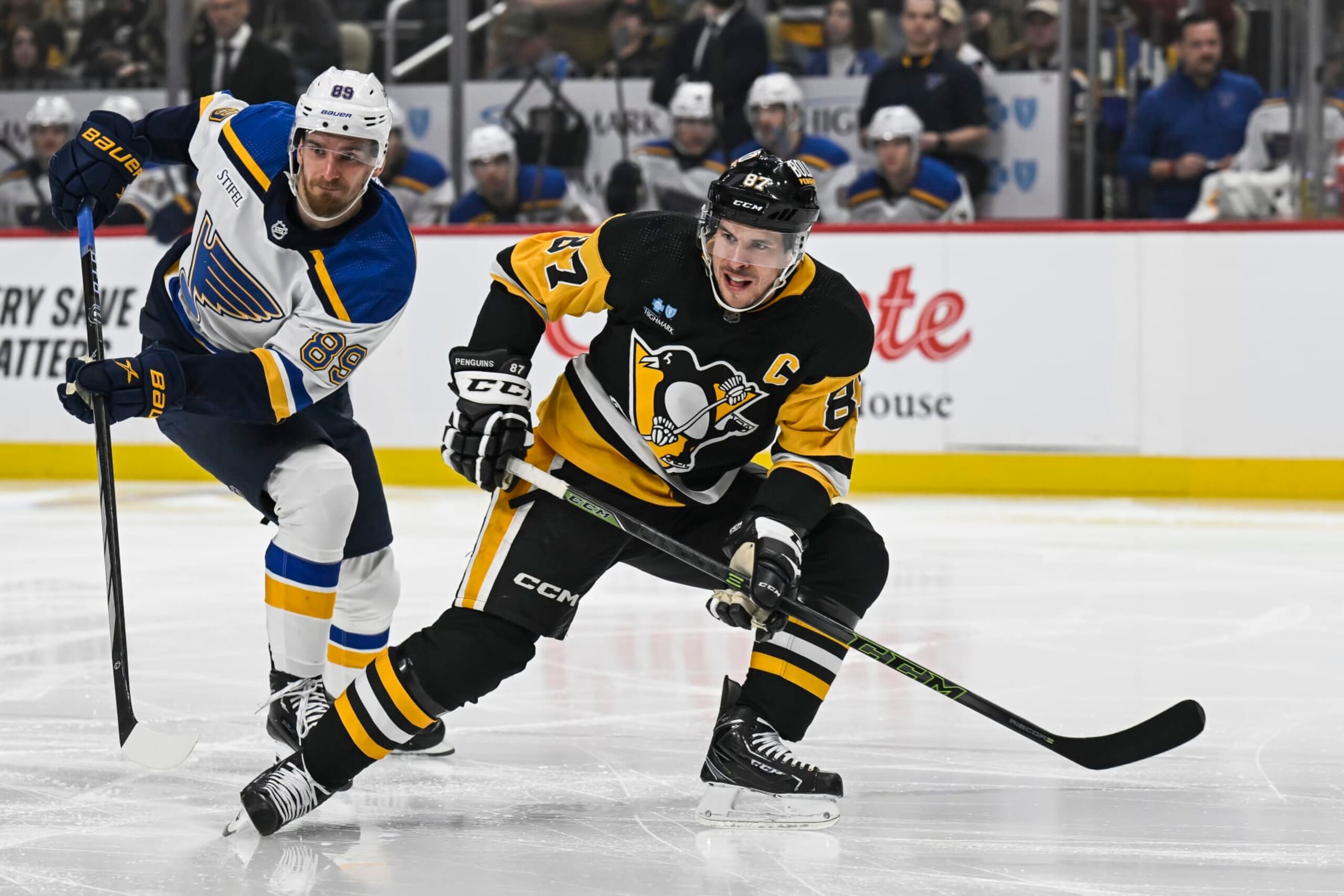 PITTSBURGH, PA - DECEMBER 30: Pittsburgh Penguins center Sidney Crosby (87) looks for a pass as St. Louis Blues left wing Pavel Buchnevich (89) defends during the first period in the NHL game between the Pittsburgh Penguins and the  St. Louis Blues on December 30, 2023, at PPG Paints Arena in Pittsburgh, PA. (Photo by Jeanine Leech/Icon Sportswire via Getty Images)