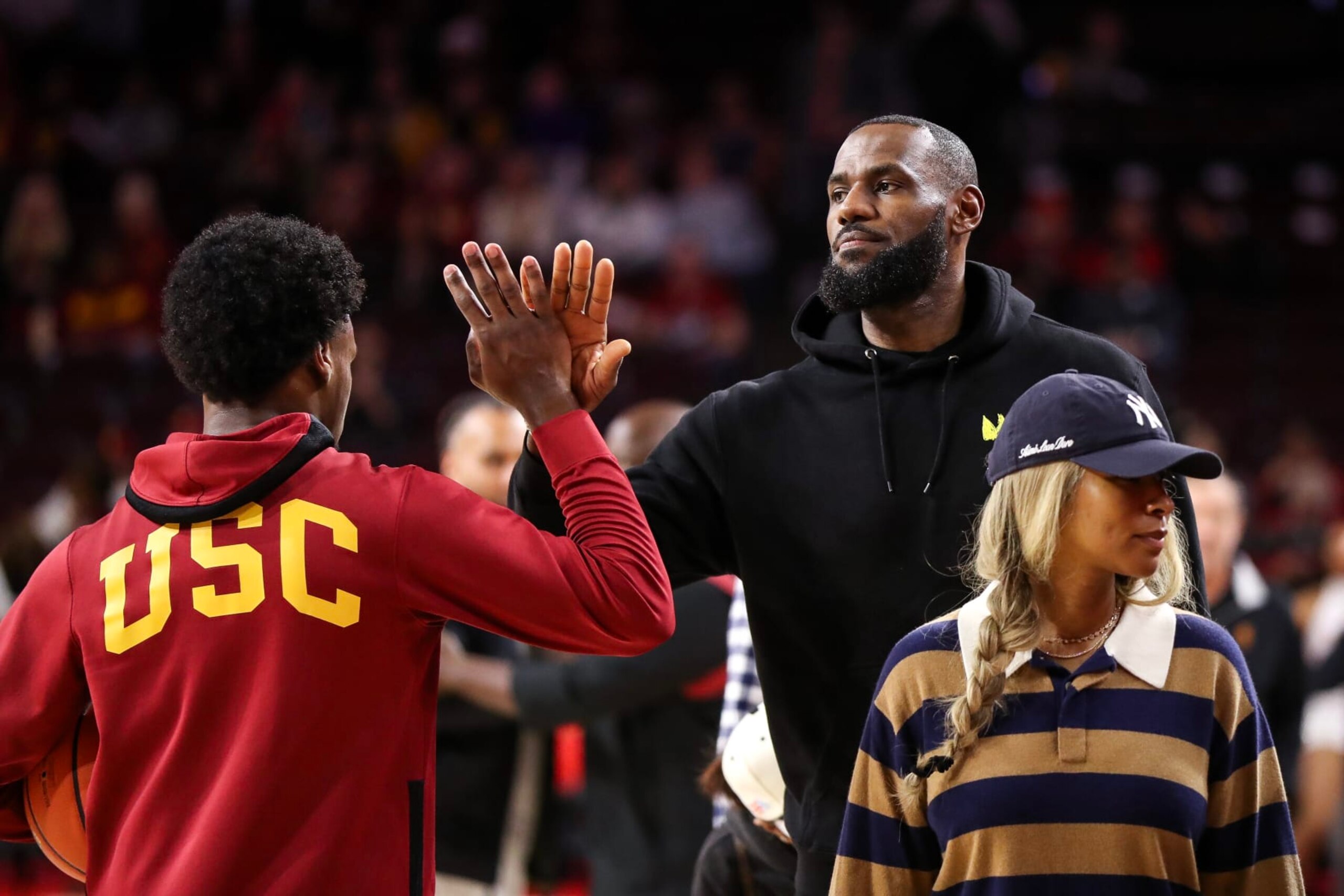 LOS ANGELES, CALIFORNIA - JANUARY 06: Bronny James #6 of the USC Trojans greets his dad, LeBron James of the Los Angeles Lakers,  before the game against the Stanford Cardinal at Galen Center on January 06, 2024 in Los Angeles, California. (Photo by Meg Oliphant/Getty Images)