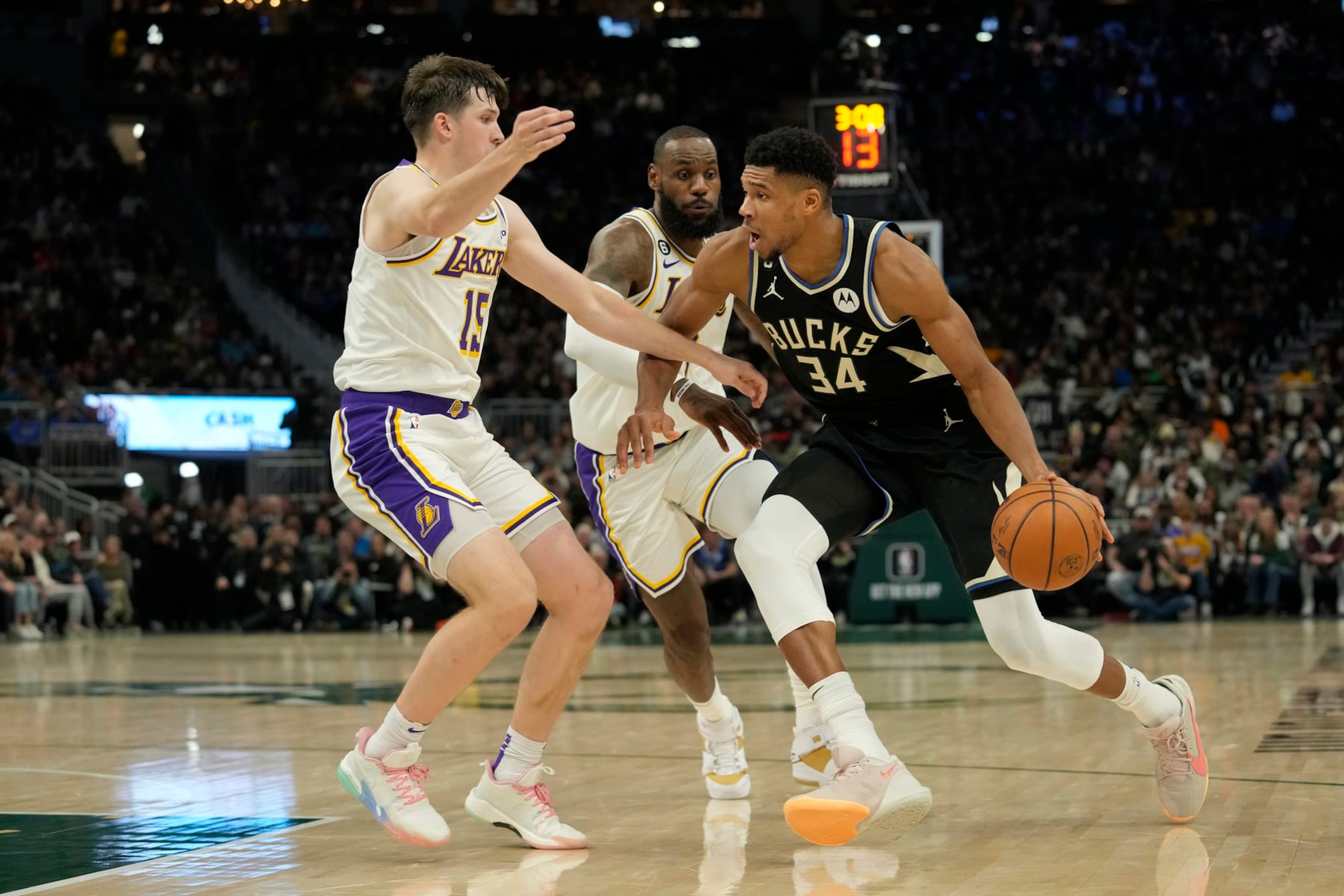 MILWAUKEE, WISCONSIN - DECEMBER 02: Giannis Antetokounmpo #34 of the Milwaukee Bucks dribbles the ball against Austin Reaves #15 and LeBron James #6 of the Los Angeles Lakers during the second half at Fiserv Forum on December 02, 2022 in Milwaukee, Wisconsin. NOTE TO USER: User expressly acknowledges and agrees that, by downloading and or using this photograph, User is consenting to the terms and conditions of the Getty Images License Agreement. (Photo by Patrick McDermott/Getty Images)