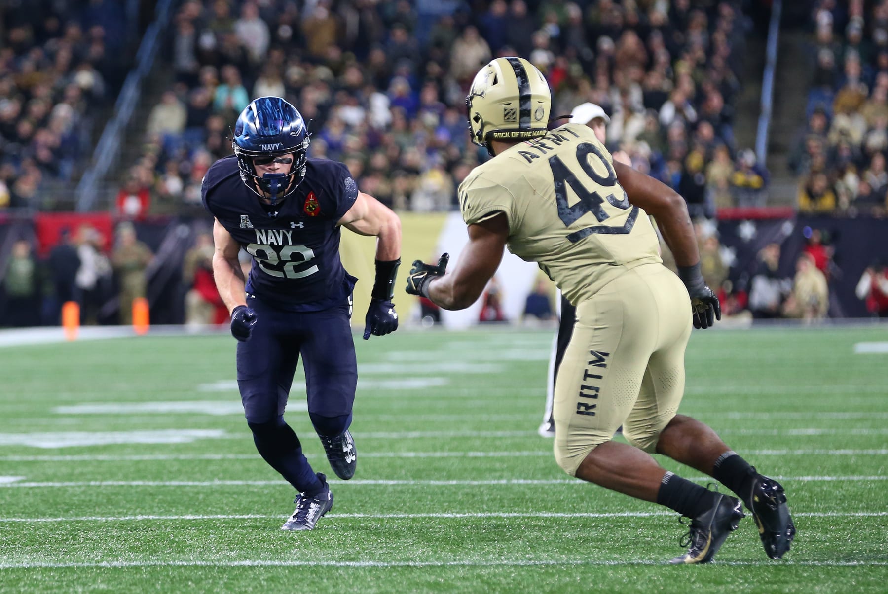 FOXBOROUGH, MA - DECEMBER 09:Navy Midshipmen running back Eli Heidenreich (22) defended by Army Black Knights linebacker Jackson Powell (49) during the 124th Army-Navy football game on December 9, 2023, at Gillette Stadium in Foxborough, MA. (Photo by M. Anthony Nesmith/Icon Sportswire via Getty Images)