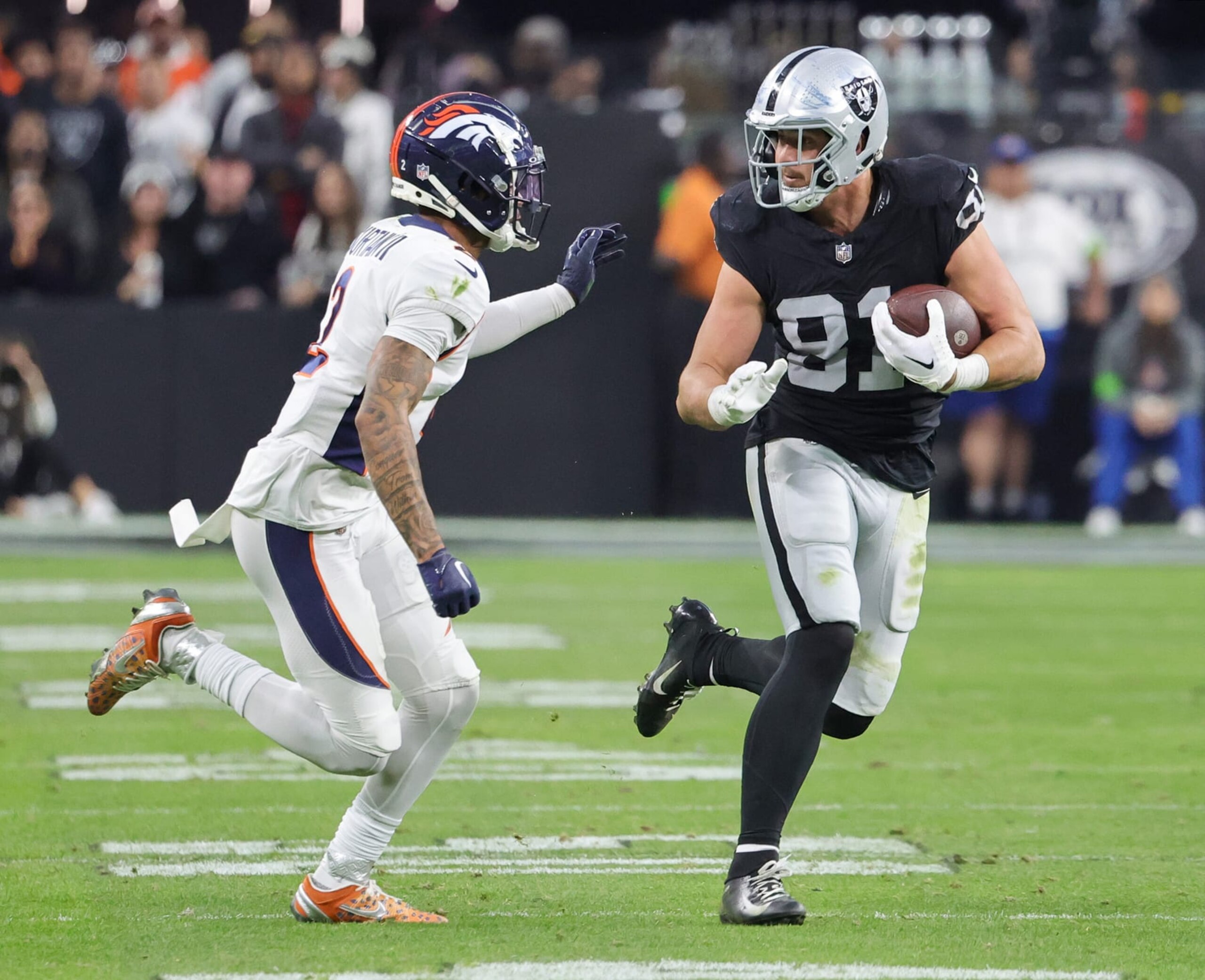 LAS VEGAS, NEVADA - JANUARY 07: Tight end Austin Hooper #81 of the Las Vegas Raiders runs for a first down against cornerback Pat Surtain II #2 of the Denver Broncos after a catch in the fourth quarter of their game at Allegiant Stadium on January 07, 2024 in Las Vegas, Nevada. The Raiders defeated the Broncos 27-14. (Photo by Ethan Miller/Getty Images) LAS VEGAS, NEVADA - JANUARY 07: Tight end Austin Hooper #81 of the Las Vegas Raiders runs for a first down against cornerback Pat Surtain II #2 of the Denver Broncos after a catch in the fourth quarter of their game at Allegiant Stadium on January 07, 2024 in Las Vegas, Nevada. The Raiders defeated the Broncos 27-14. (Photo by Ethan Miller/Getty Images)