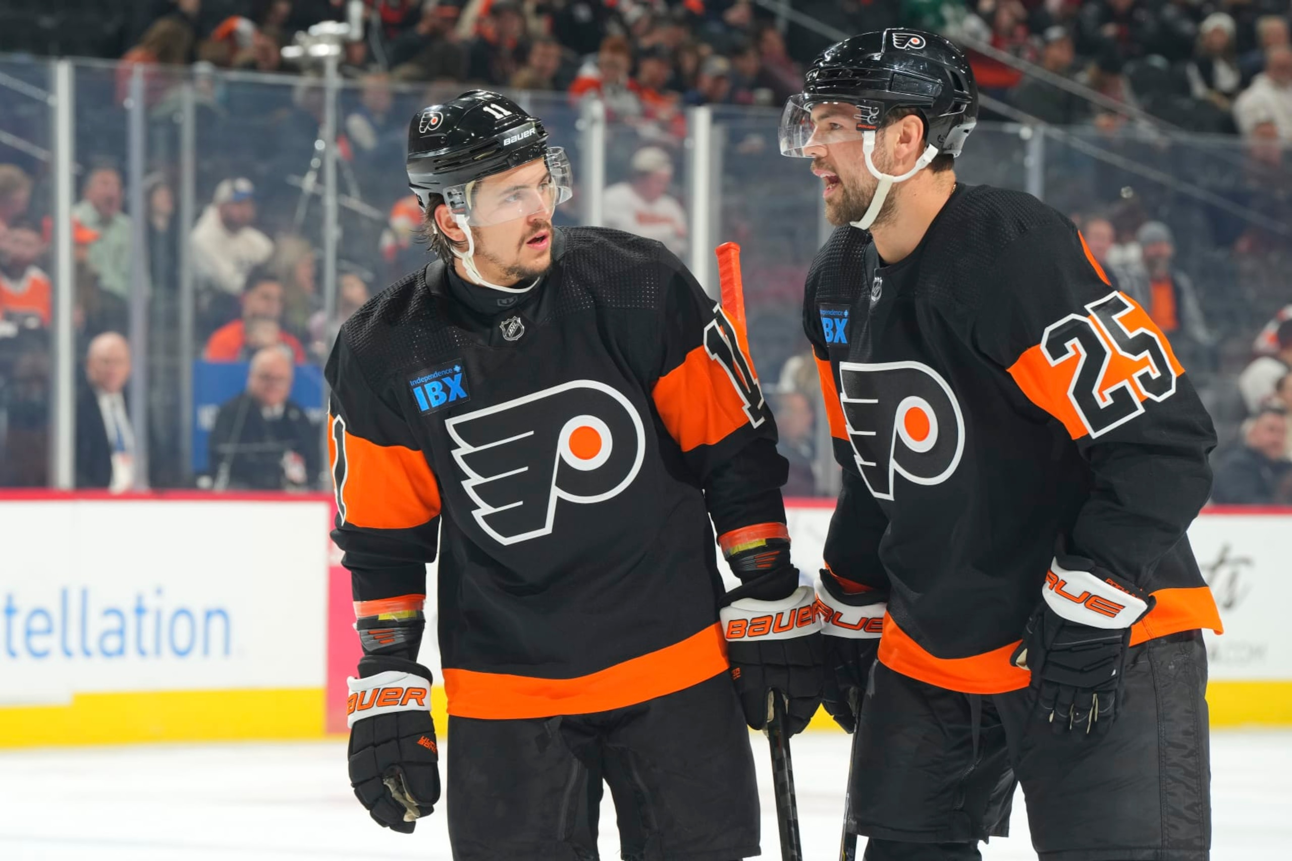 PHILADELPHIA, PENNSYLVANIA - FEBRUARY 12: Travis Konecny #11 of the Philadelphia Flyers talks to Ryan Poehling #25 against the Arizona Coyotes at the Wells Fargo Center on February 12, 2024 in Philadelphia, Pennsylvania. The Flyers defeated the Coyotes 5-3. (Photo by Mitchell Leff/Getty Images)