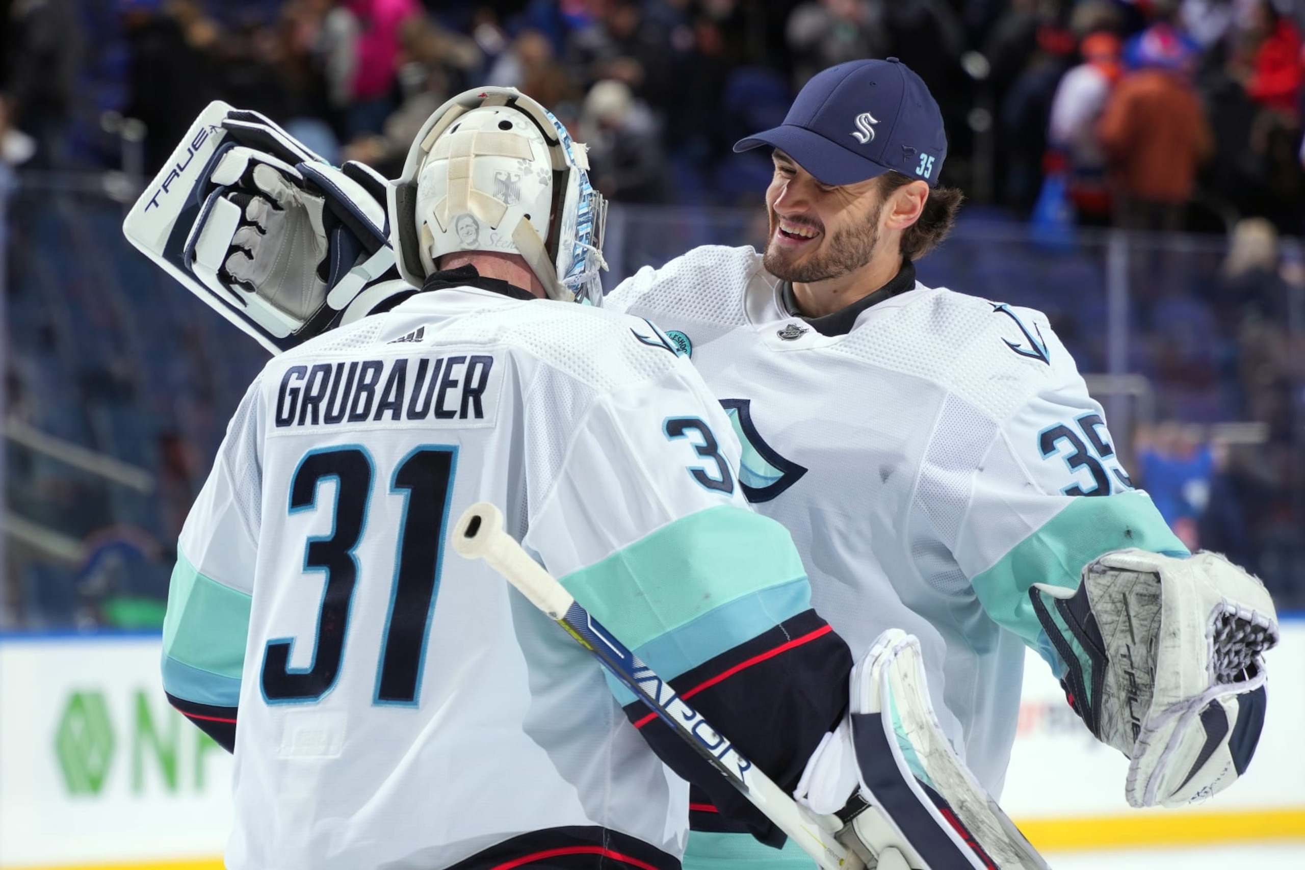 ELMONT, NEW YORK - FEBRUARY 13:  Philipp Grubauer #31 of the Seattle Kraken and Joey Daccord #35 celebrate the 2-1 overtime shootout win against the New York Islanders at UBS Arena on February 13, 2024 in Elmont, New York. (Photo by Mike Stobe/NHLI via Getty Images)