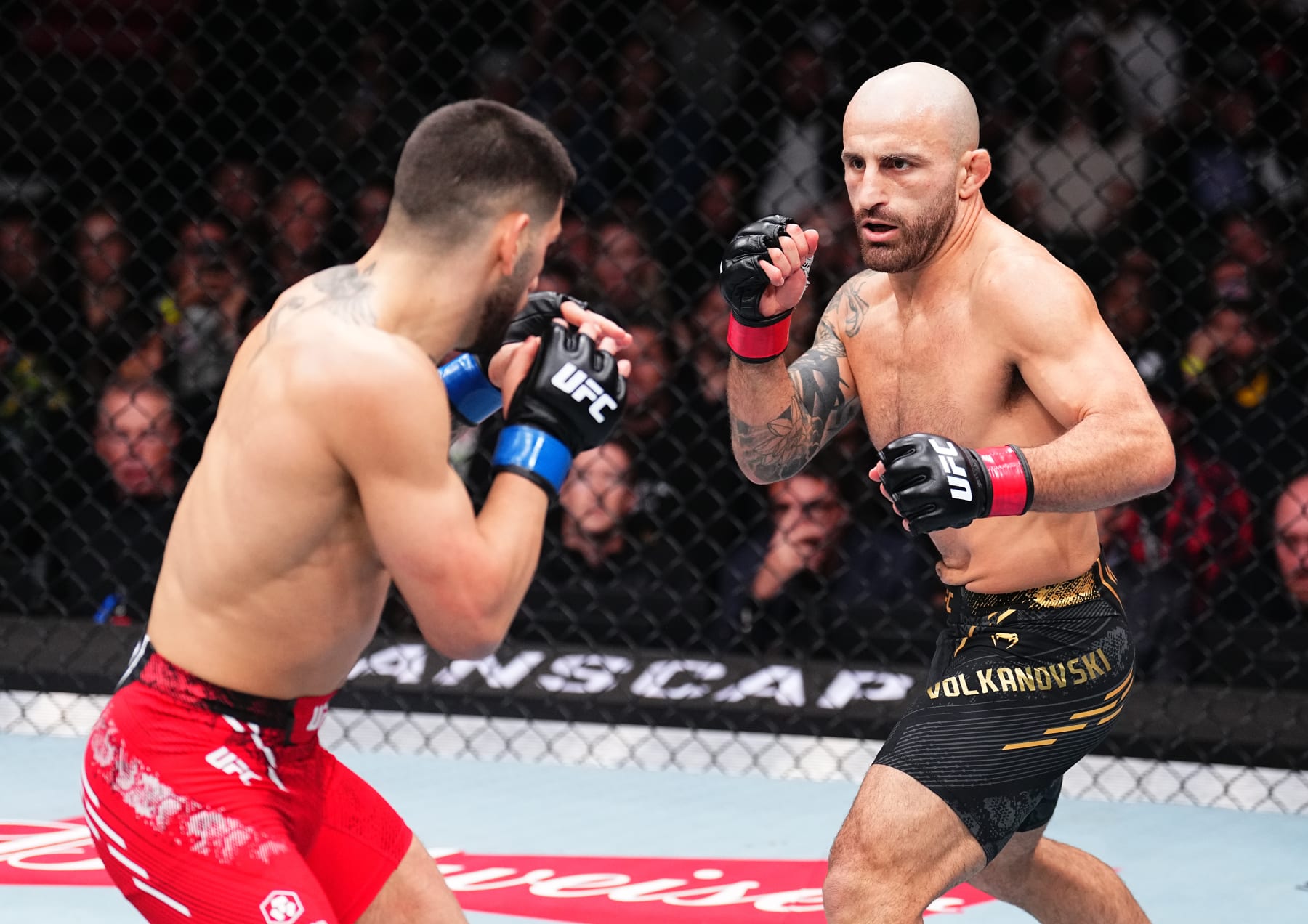 ANAHEIM, CALIFORNIA - FEBRUARY 17: (R-L) Alexander Volkanovski of Australia battles Ilia Topuria of Germany in the UFC featherweight championship fight during the UFC 298 event at Honda Center on February 17, 2024 in Anaheim, California. (Photo by Chris Unger/Zuffa LLC via Getty Images)