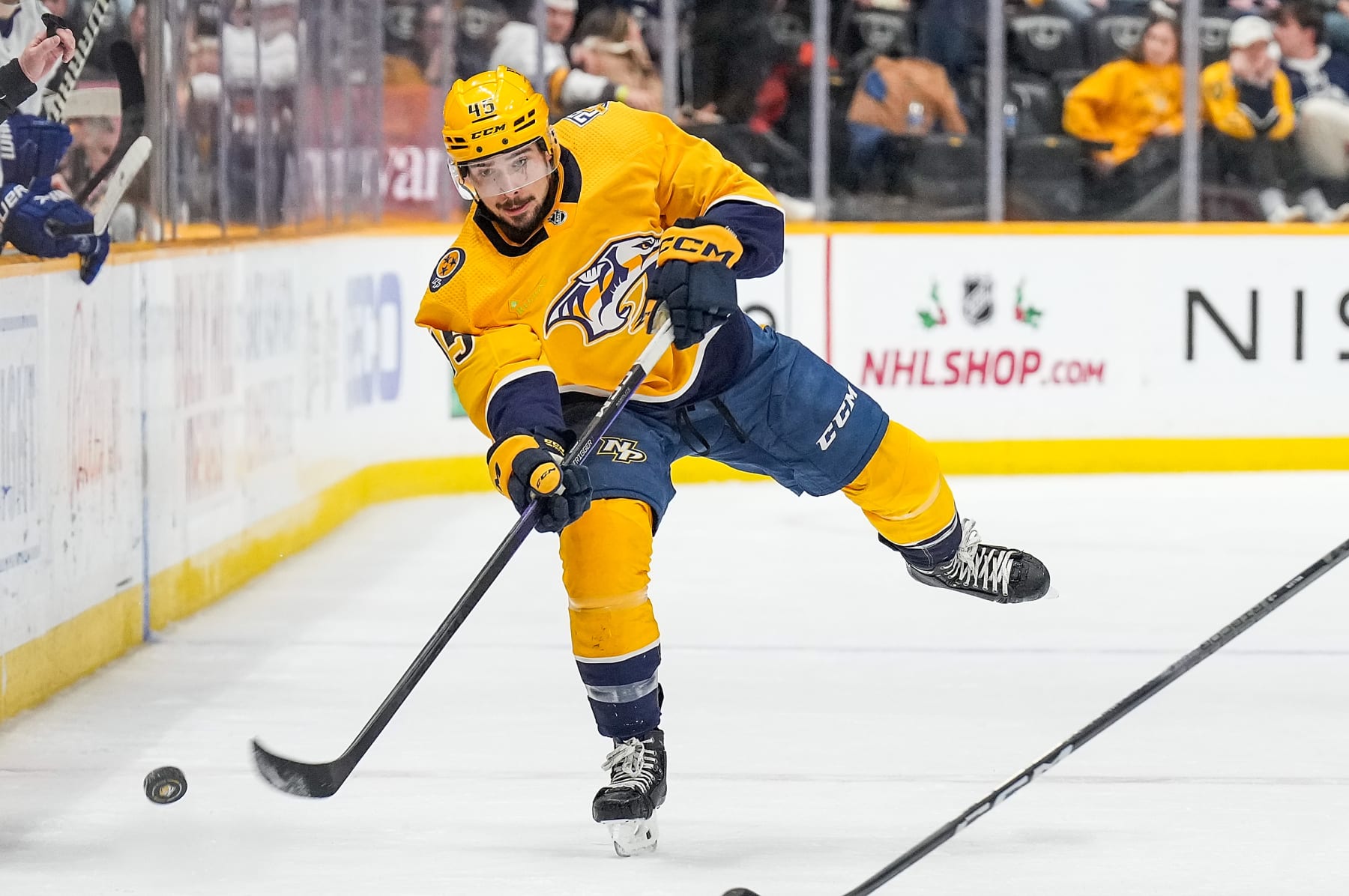 NASHVILLE, TENNESSEE - DECEMBER 19: Alexandre Carrier #45 of the Nashville Predators passes the puck against the Vancouver Canucks during an NHL game at Bridgestone Arena on December 19, 2023 in Nashville, Tennessee. (Photo by John Russell/NHLI via Getty Images)