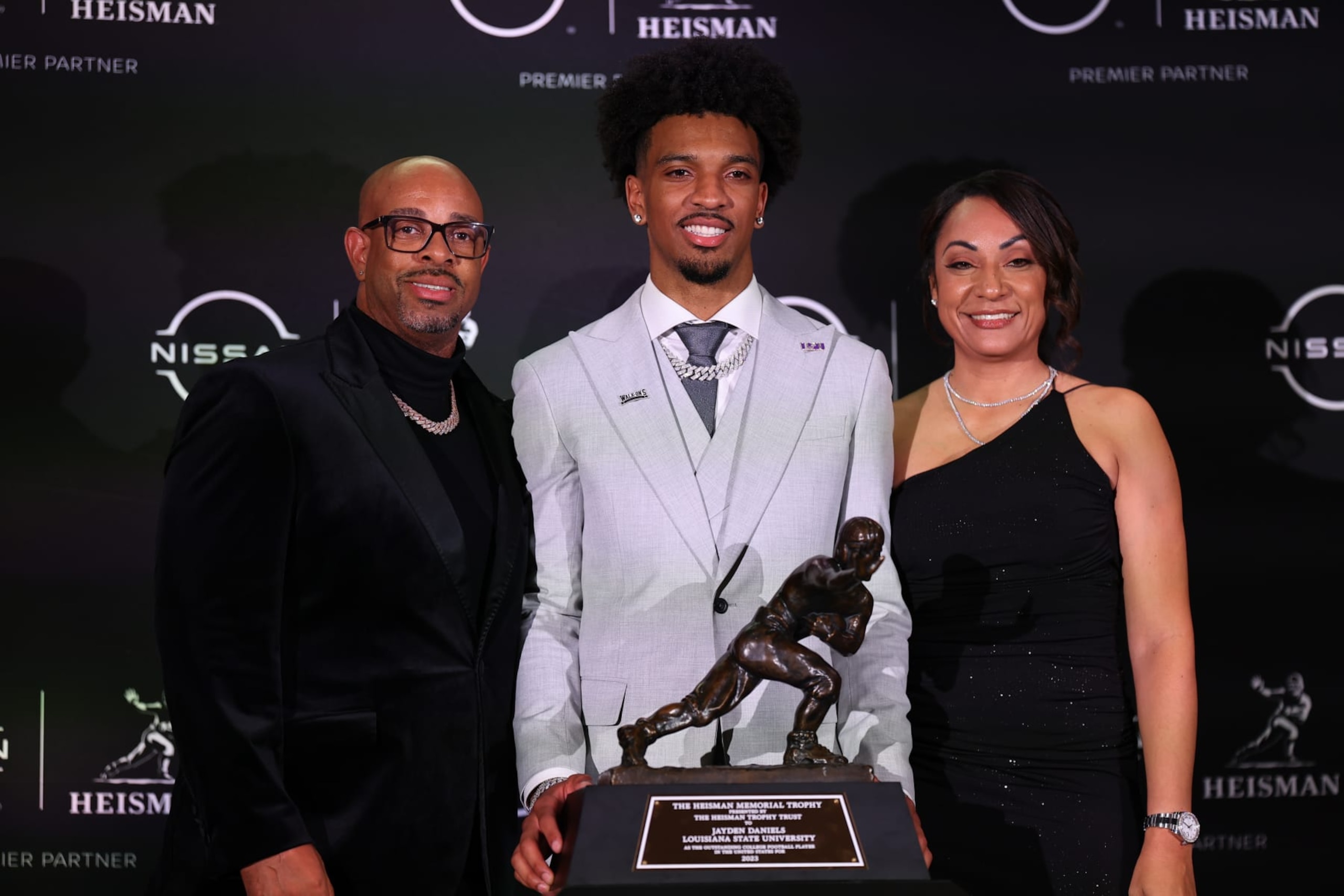 NEW YORK, NY - DECEMBER 09: Jayden Daniels quarterback LSU takes a photo with his parents and  the Heisman Trophy after winning it at the press conference at the New York Marriott Marquis on December 9, 2023 in New York City, New York.  (Photo by Rich Graessle/Icon Sportswire via Getty Images)