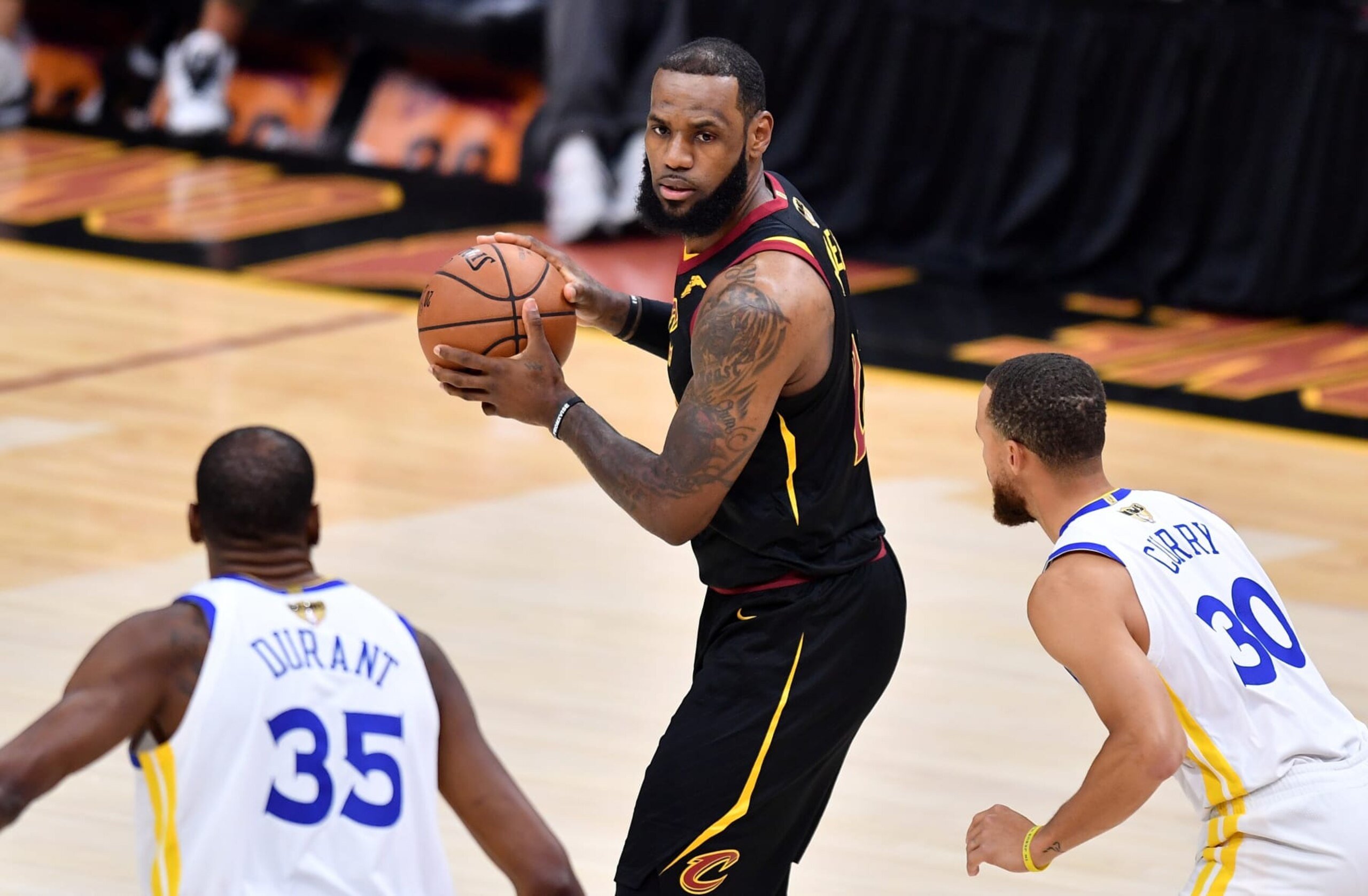 CLEVELAND, OH - JUNE 06:  LeBron James #23 of the Cleveland Cavaliers is defended by Stephen Curry #30 and Kevin Durant #35 of the Golden State Warriors in the first quarter during Game Three of the 2018 NBA Finals at Quicken Loans Arena on June 6, 2018 in Cleveland, Ohio. NOTE TO USER: User expressly acknowledges and agrees that, by downloading and or using this photograph, User is consenting to the terms and conditions of the Getty Images License Agreement.  (Photo by Jamie Sabau/Getty Images)