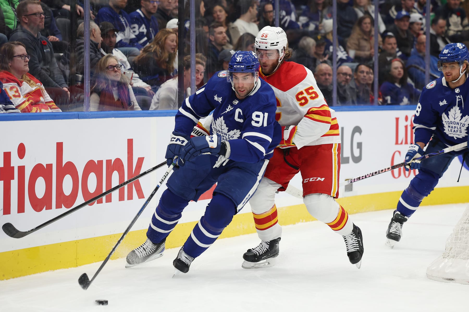 TORONTO:  Toronto Maple Leafs John Tavares( 91 blue) circles around the back of the net with Noah Hanifin ( 55) white) of the Calgary Flames in tow in NHL action on Friday .(R.J.Johnston/Toronto Star) 
         (R.J. Johnston Toronto Star/Toronto Star via Getty Images)