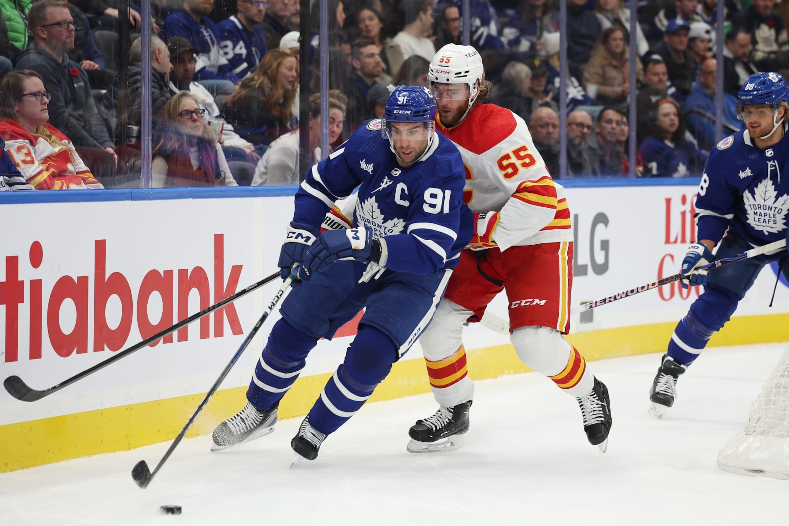 TORONTO:  Toronto Maple Leafs John Tavares( 91 blue) circles around the back of the net with Noah Hanifin ( 55) white) of the Calgary Flames in tow in NHL action on Friday .(R.J.Johnston/Toronto Star) 
         (R.J. Johnston Toronto Star/Toronto Star via Getty Images)